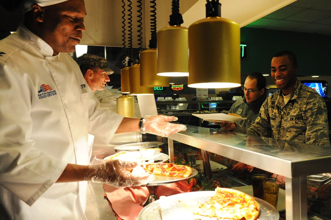 LANGLEY AIR FORCE BASE, Va. – Army Col. Reggie Austin, 633d Air Base Wing vice commander, serves a slice of pizza to Airman Whitney Williams, 438th Supply Chain Operations Squadron material manager, in the Crossbow Dining Facility Feb. 3. Each month, base commanders serve to show their appreciation to the Airmen. (U.S. Air Force photo/Senior Airman Brian Ybarbo)