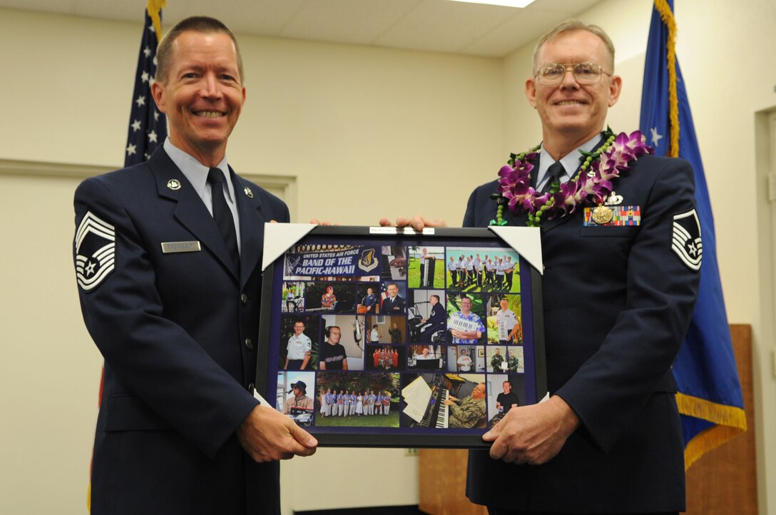 The USAF Band of the Pacific's Manager, CMSgt Larry MacTaggart, presents MSgt Daryl Yager a picture collage on the occasion of his retirement from active duty