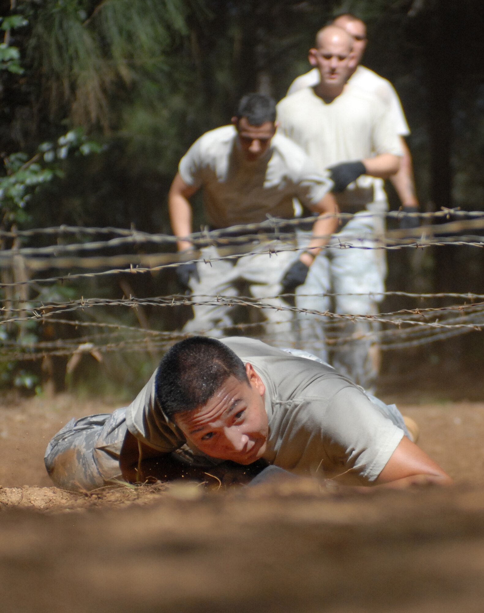 Senior Airman Anthony Elizondo, a 647th Security Forces Squadron Airman from Joint Base Pearl Harbor-Hickam, Hawaii, low crawls under barbed wire as part of an obstacle course Feb. 1, 2011, in Wahiawa, Hawaii. A total of 16 security forces members are trying out in order to attend a two-week Army Air Assault Course beginning May 5, 2011. These try-outs will help the Air Force security forces NCO in charge of training determine which Airmen he will send to this challenging course. (U.S. Air Force photo/Staff Sgt. Carolyn Viss)