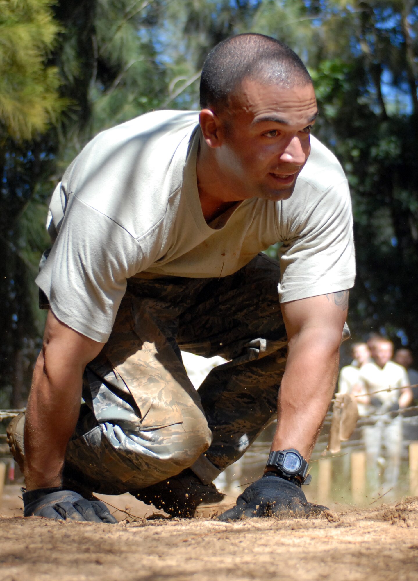 U.S. Air Force Tech. Sgt. Pablo Gonzalez, a 647th Security Forces Squadron Airman, pops up from under barbed wire while completing an obstacle on a course owned by Schofield Barracks Feb. 1, 2011, in Wahiawa, Hawaii. He and 15 other 647th SFS Airmen from Joint Base Pearl Harbor-Hickam, Hawaii, were trying out for the two-week Army Air Assault Course  beginning May 5, 2011. These try-outs will help the Air Force security forces NCO in charge of training determine which Airmen he will send to this challenging course. (U.S. Air Force photo/Staff Sgt. Carolyn Viss)
