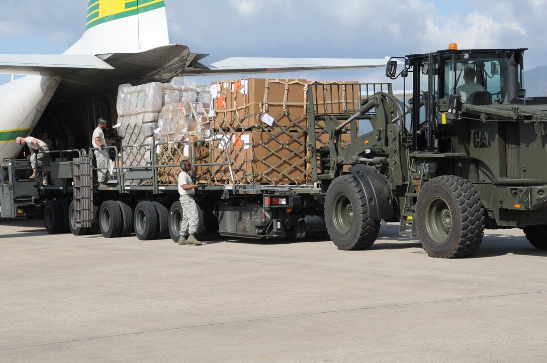 Joint Task Force-Bravo receives a supply shipment from a L-100, Jan. 26. Shipments include miscellaneous supplies along with medical items and Army and Air Force Exchange frozen foods. With assistance from Staff Sgts Cory Willits and Phillip Brown, Senior Airman Justin McGhee locks the arriving pallets down to the deck of the 60K then Staff Sgt. Elliot Mason holds the pallet stop down at the end of the K-loader where Tech. Sgt. Zachary Brown offloads the pallet with a 10K-AT forklift driver.  JTF-Bravo provides a semi-permanent U.S. military presence to coordinate U.S. Armed Forces and exercise activities within the Joint Area of Operations. (U.S. Air Force photo/Staff Sgt. Kimberly Rae Moore)