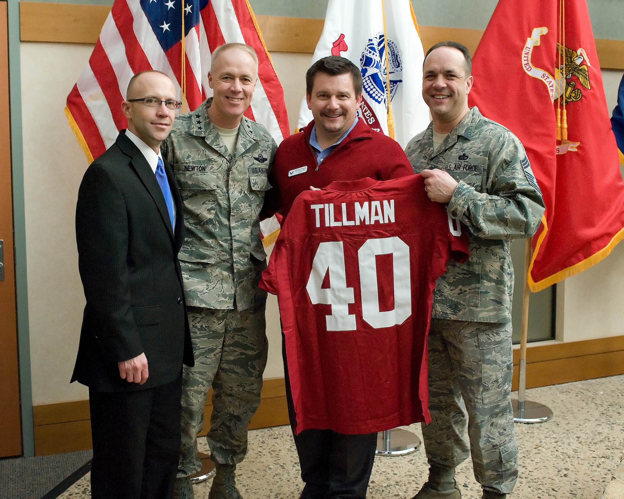 Lt. Gen. Richard Y. Newton III, Air Staff, Headquarters U.S. Air Force, Washington, D.C., assistant vice chief of staff and director, accepts a Pat Tillman jersey from Michael Bidwill, president of the Arizona Cardinals Football Club. Trevor Dean, deputy to the commander, Air Force Mortuary Affairs Operations and Chief Master Sgt. David Fish, chief enlisted manager accept the jersey on behalf of AFMAO. (U.S. Air Force photo/Jason Minto)