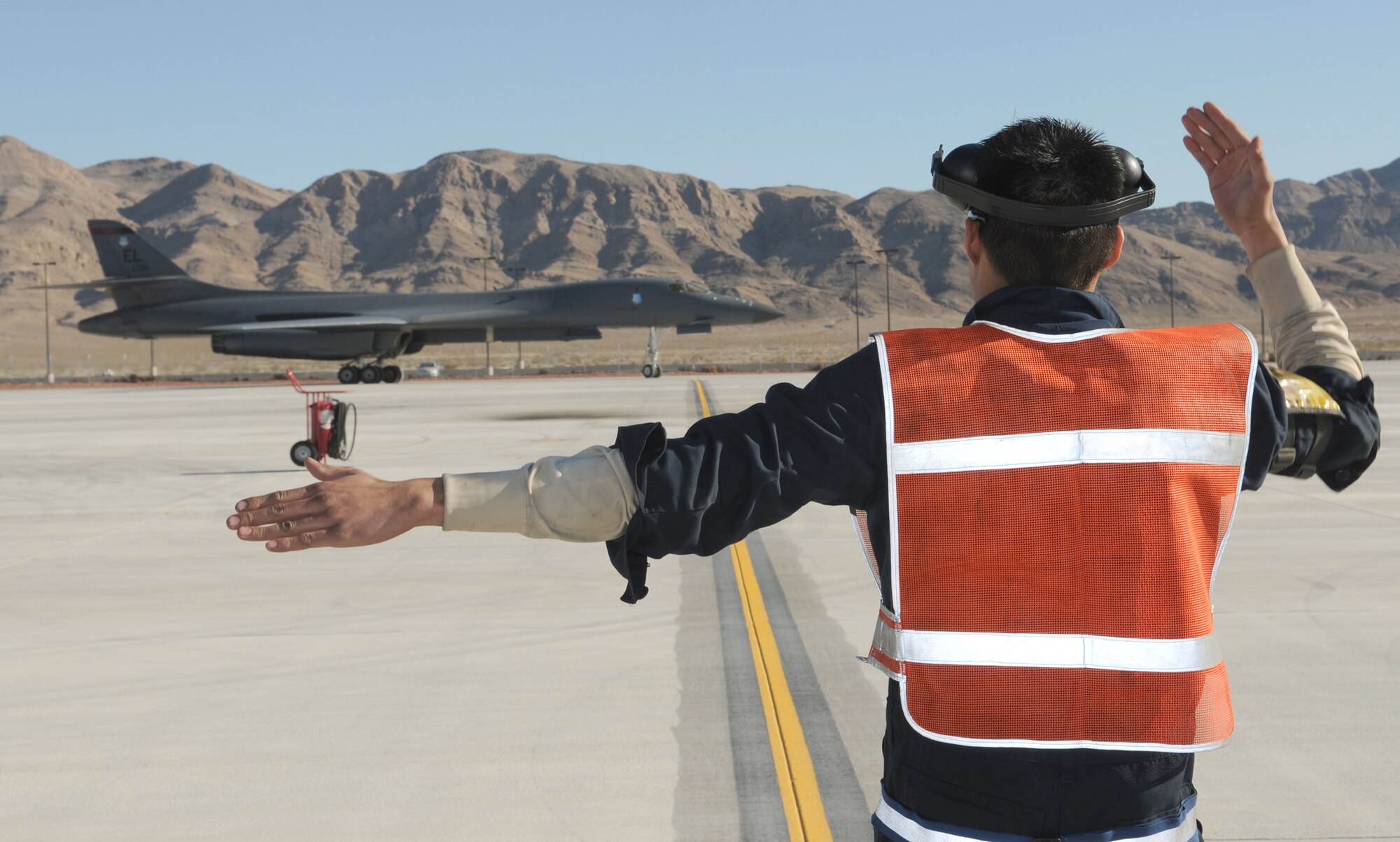 Senior Airman Kevin Faulds marshals a B-1 Lancer Jan. 26, 2011, at Nellis Air Force Base, Nev., after an exercise Red Flag mission. Airman Faulds is a crew chief assigned to the 28th Aircraft Maintenance Squadron at Ellsworth AFB, S.D. (U.S. Air Force photo/Staff Sgt. Benjamin Wilson)
