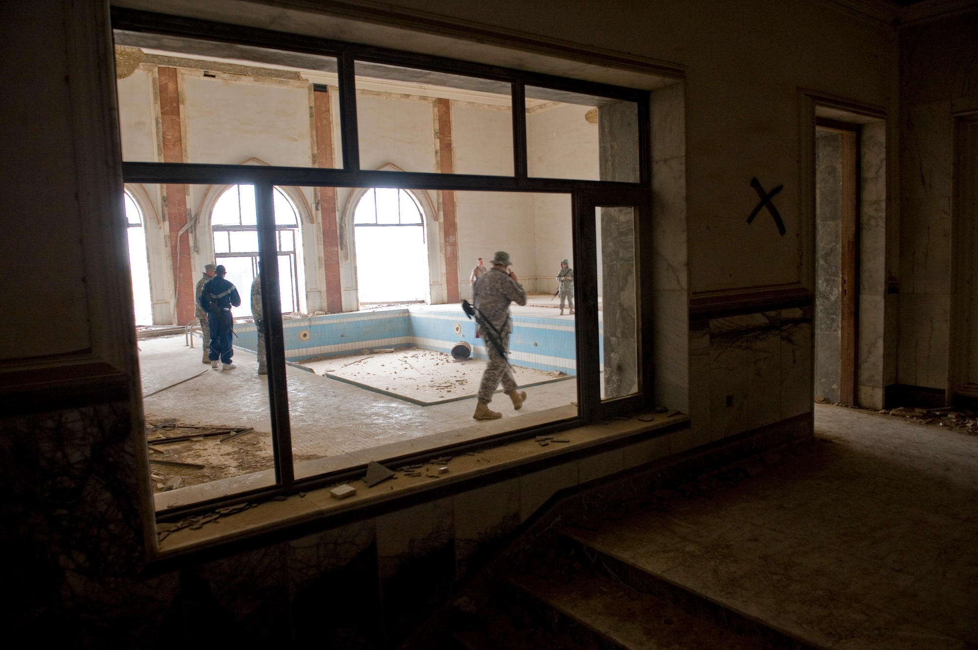 Service members stationed in Baghdad explore the Baath Party House during a tour of historic buildings at Baghdad, Jan. 29. The pool in the house was never filled with water; instead Baath party members used the pool as a make-shift torture chamber. (U.S. Air Force photo/Staff Sgt. Levi Riendeau) 