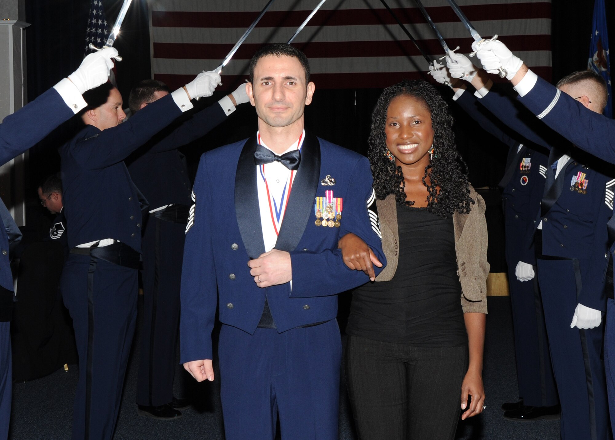 Senior Master Sgt. Brian Kruzelnick, 22nd Aircraft Maintenance Squadron Aircraft Maintenance Unit superintendent, and wife Kareen Kruzelnick, walk through the sabers as part of the annual awards ceremony held in the Robert J. Dole Community Center ballroom, Jan. 28, 2011, McConnell Air Force Base, Kan.  Sergeant Kruzelnick is McConnell’s 2010 Senior Noncommissioned Officer of the Year. (U.S. Air Force photo/Airman 1st Class Katrina M. Brisbin)