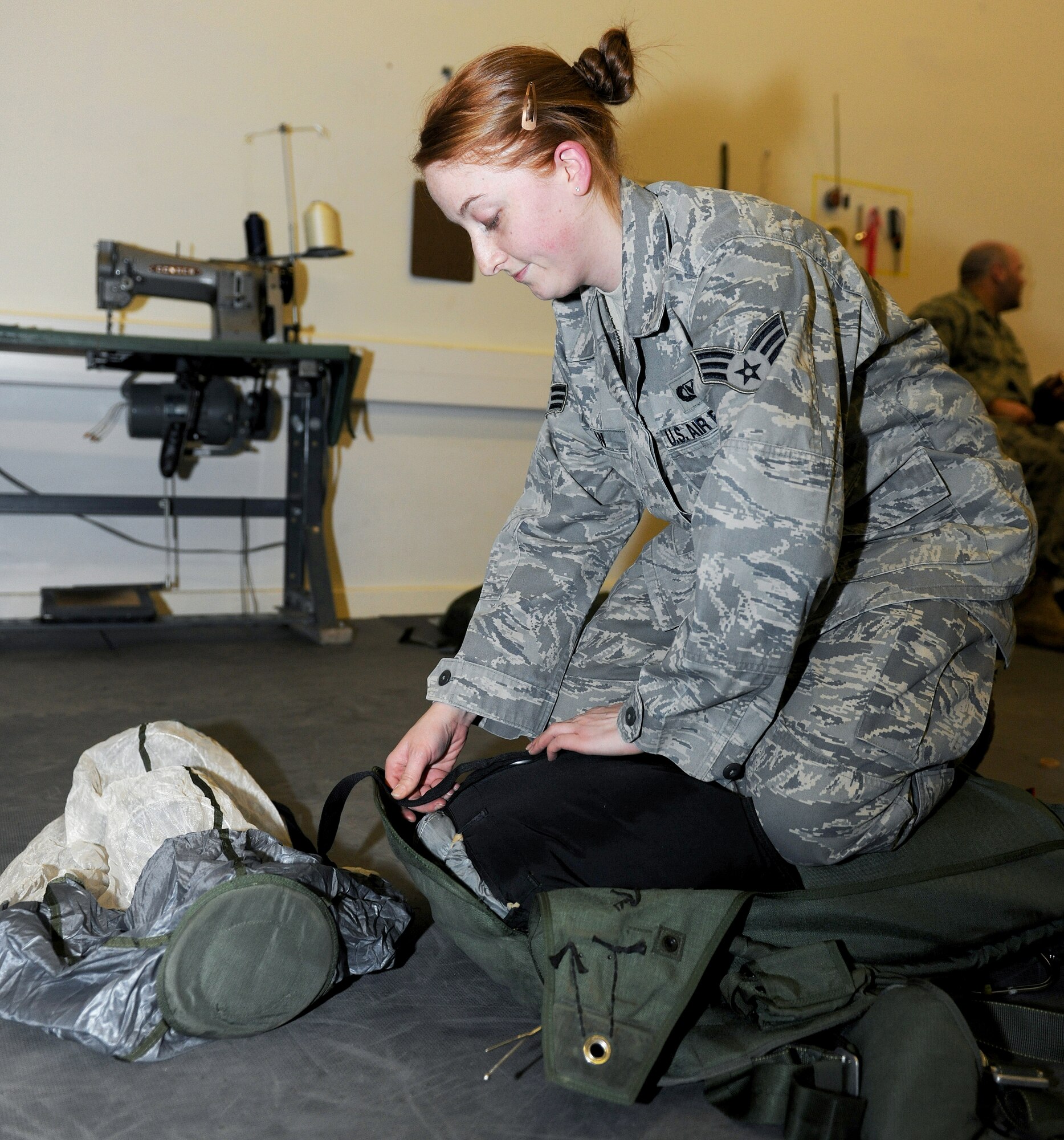 RAF MILDENHALL, England -- Senior Airman Holly Dean, 100th Operation Support Squadron air crew flight equipment journeyman, packs a primary MC-4 parachute here Feb. 1, 2011.  These parachutes are used by Air Force Special Operation Command pararescuemen and combat controllers during training exercises. (U.S. Air Force photo/Senior Airman Tabitha M. Lee) 