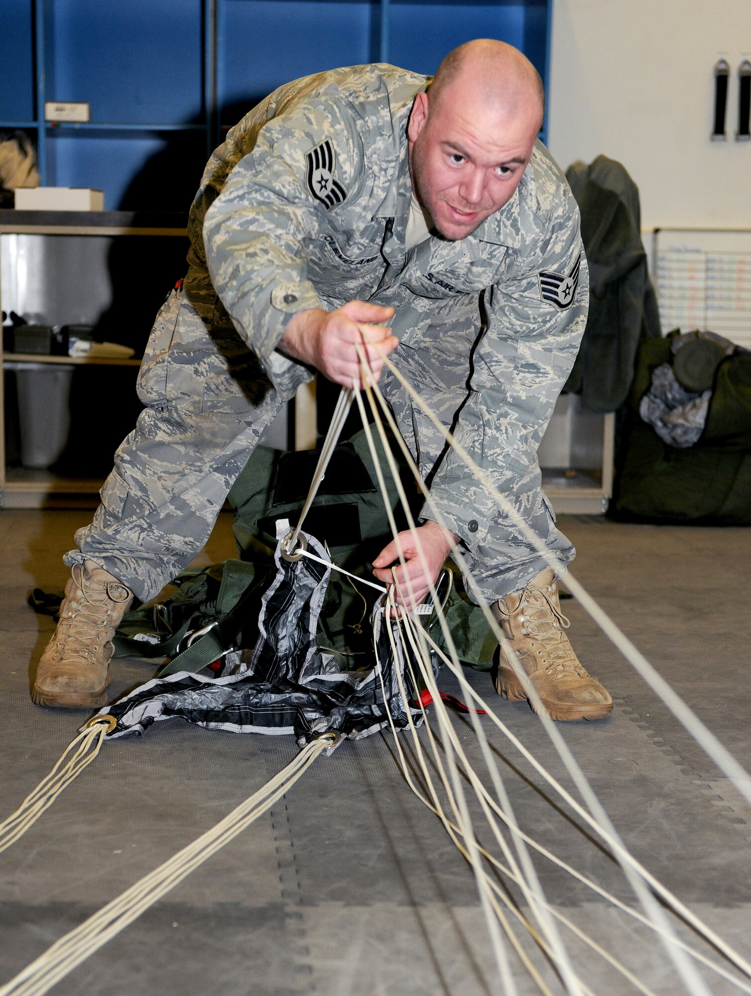 RAF MILDENHALL, England -- Staff Sgt. Don Cleveland, 100th Operation Support Squadron air crew flight equipment craftsman, does an inprocess inspection on a reserve MC-4 parachute here Feb. 1, 2011.  During the inprocess inspection, Sergeant Cleveland completes a rigger check to guarantee line continuity, ensuring the lines will function properly when the parachute is deployed. (U.S. Air Force photo/Senior Airman Tabitha M. Lee) 