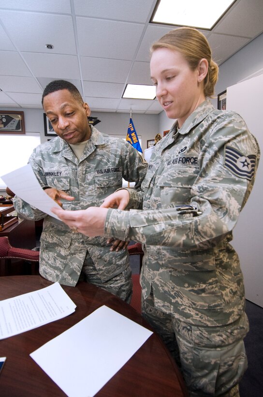 Technical Sgt. Esther Keeney, right, 11th Wing command chief executive assistant, goes over the distinguished visitors list for an upcoming Team Andrews fourth quarter awards ceremony with Chief Master Sgt. Anthony Brinkley, Joint Base Andrews command chief master sergeant,.  Sergeant Keeney is responsible for coordinating the command chief’s itineraries, as well as reviewing, editing, prioritizing and tracking executive correspondence and managing his calendar appointments.  (U.S. Air Force photo/Bobby Jones)