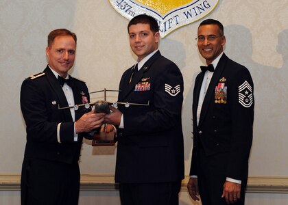 Col. John Wood, left, and Chief Master Sgt. Terrence Greene, right, presents Staff Sgt. Spencer Stacey the volunteer of the Year award for 2010 during the annual awards banquet held at the Charleston Club Feb 2. Airmen and civilians were presented an award for their outstanding accomplishments from one of the 15 different different categories recognized. Unable to attend the banquet due to deployment or other reasons were, from the 437th Operations Support Squadron, Airmen of the Year Senior Airman John Konkol; from the 16th Airlift Squadron, Senior Noncommissioned Officer of the Year Master Sgt. Jefferey Faretra; from the 437th Aircraft Maintenance Squadron, Second Leiutenant Travis Mongeon; and from the 16th Airlift Squadron, Civilian Category 1 of the Year Mr. Timothy Peyton. Colonel Wood is the 437th Airlift Wing commander, Chief Greene is the 437th Airlift Wing command chief and Sergeant Stacey is from the 17th Airlift Squadron. (U.S. Air Force photo/Senior Airman Timothy Taylor)