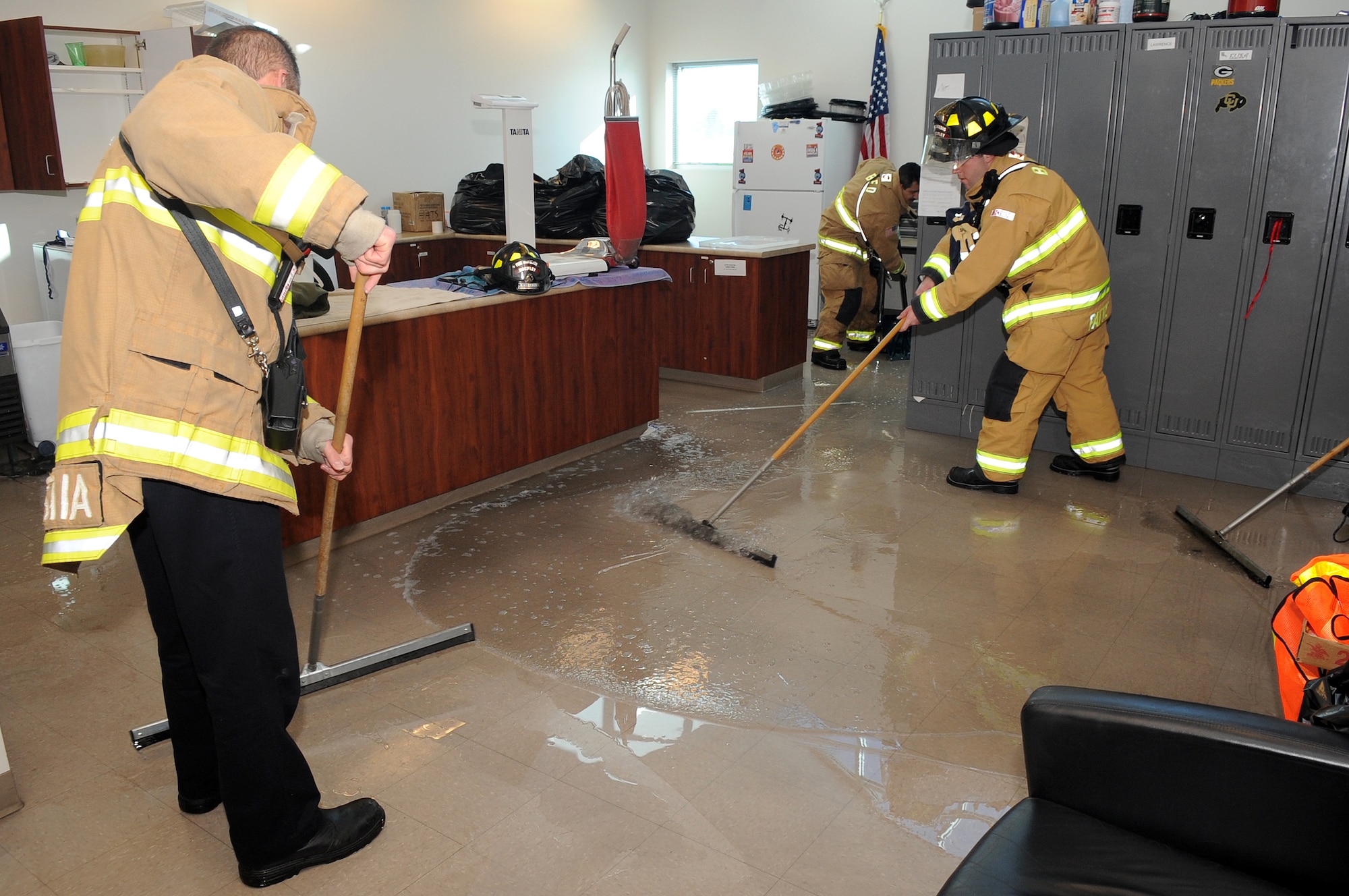 BUCKLEY AIR FORCE BASE, Colo.-- Buckley Fire Department works to clean up the Buckley Fitness Center after a pipe burst in the main lobby, Feb. 2, 2011. The HAWC entrance will be open for the individuals taking Fitness Assessments and Physical Therapy.   (U.S. Air Force photo by Airman Manisha Vasquez) 