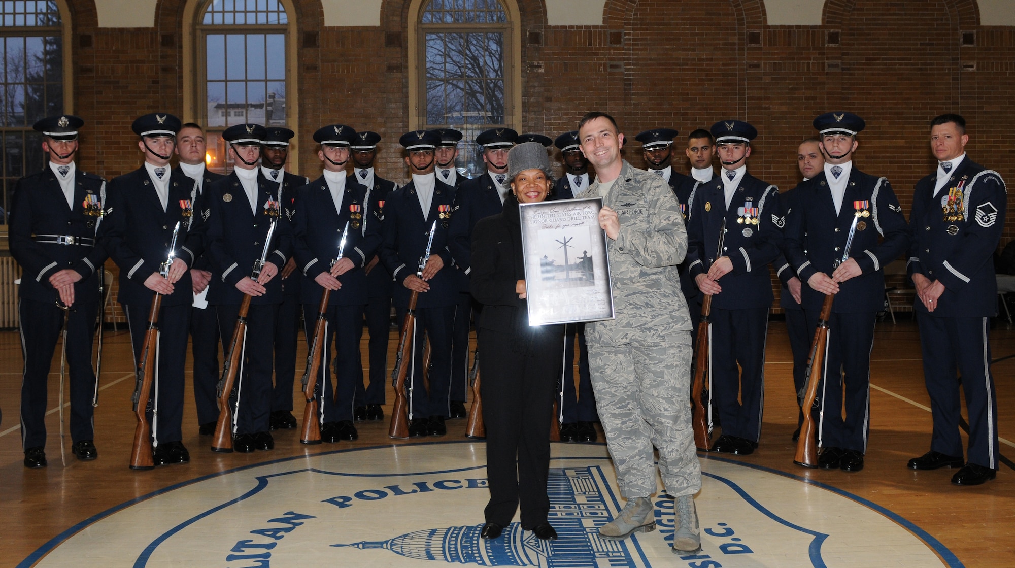 Lt. Col. Raymond M. Powell, commander of The U.S Air Force Honor Guard, presents an autographed photo to Ms. Pandit Wright, honorary commander of the USAF Honor Guard Jan. 21 at the Boys and Girls Club of D.C., Washington D.C.  Ms. Wright assisted in organizing the performance for the local community. (U.S. Air Force photo by Senior Airman Christopher Ruano)