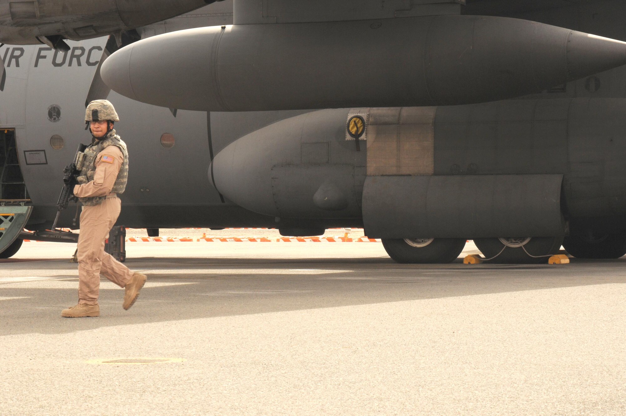 Airman 1st Class Kenneth Rivera-Ithier, a Fly Away Security Team member with the 386th Expeditionary Security Forces Squadron guards a C-130H Hercules during a FAST demonstration at the Quarry Open House Feb. 2. Airmen with the 386th Air Expeditionary Wing, also known as The Rock, were given the opportunity to visit the Quarry, or flightline, and see all the different parts involved with getting the flying mission accomplished. (U.S. Air Force Photo by Staff Sgt. Patrice Clarke)