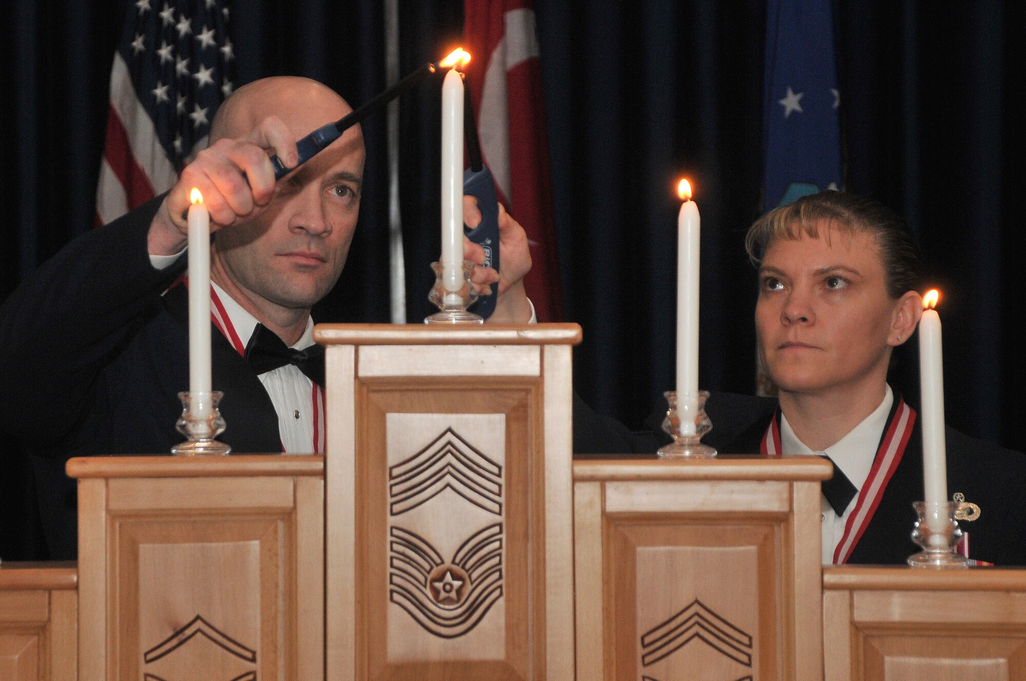 Senior Master Sgt. Brett Rodgers, the 39th Civil Engineer Squadron Explosive Ordinance Disposal Flight chief, and Senior Master Sgt. Teresa Clapper, the 39th Force Support Squadron Manpower and Organization Section chief light a candle to symbolize their selection for promotion to the rank of chief master sergeant during a chief master sergeant recognition ceremony Jan. 28, at Incirlik Air Base, Turkey. The chief master sergeant recognition ceremony is one of the oldest military traditions, and honors those who achieve the highest enlisted rank in the Air Force. The Air Force only promotes 1 percent of its enlisted force to the rank of chief master sergeant.   (U.S. Air Force photo by Staff Sgt. Alexandre Montes/Released)