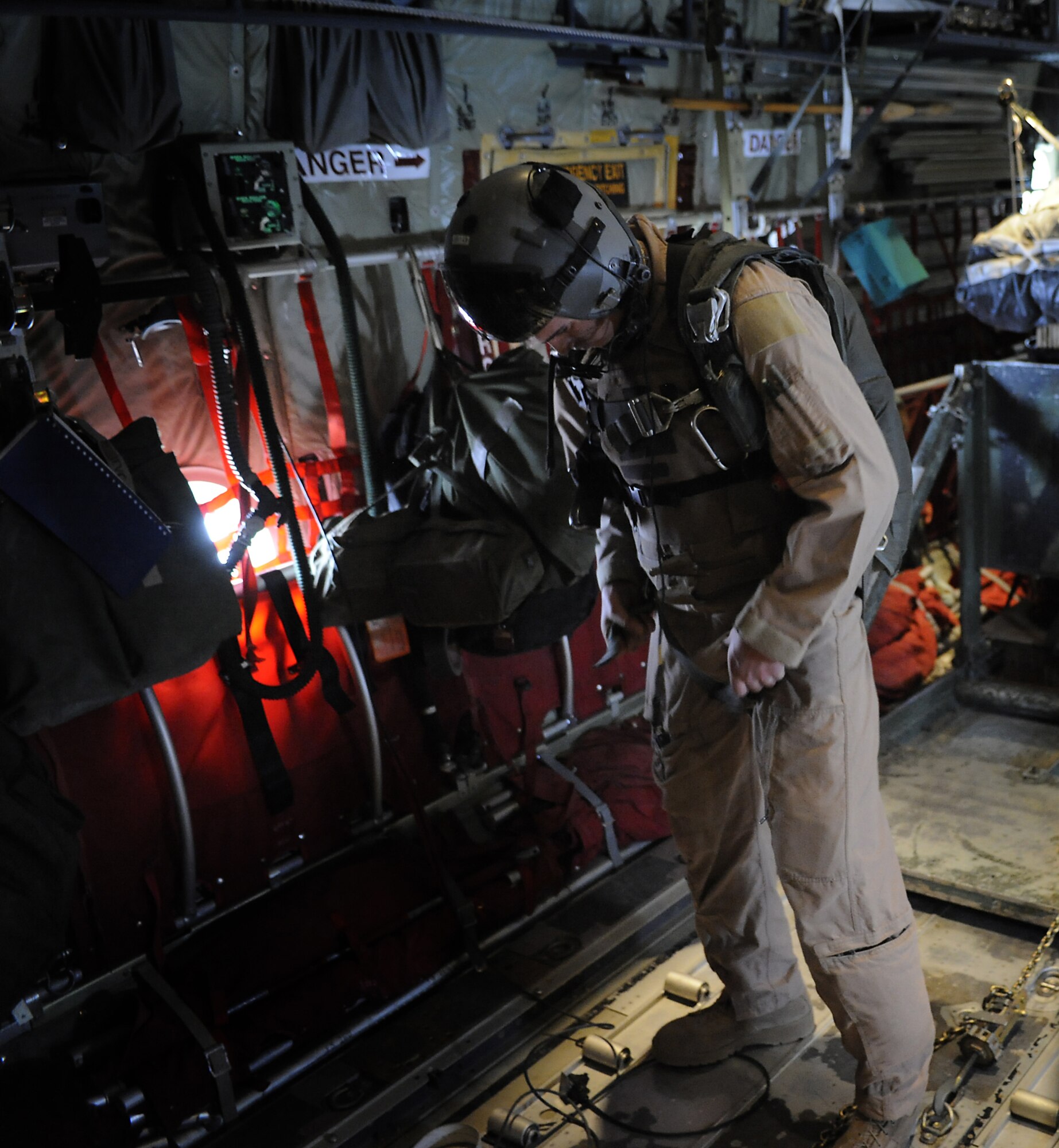 Tech. Sgt. Josh Romero puts a parachute on while preparing for an airdrop mission Feb. 2, 2011, at Kandahar Airfield, Afghanistan. During the month of January, the 772nd Expeditionary Airlift Squadron moved close to 4,000 passengers and flew more than 420 sorties with approximately 400 flight hours and also broke a record by completing 51 airdrop missions in a one-month period. Sergeant Romero is a loadmaster assigned to the 772nd EAS. (U.S. Air Force photo/Senior Airman Willard E. Grande II/Released)