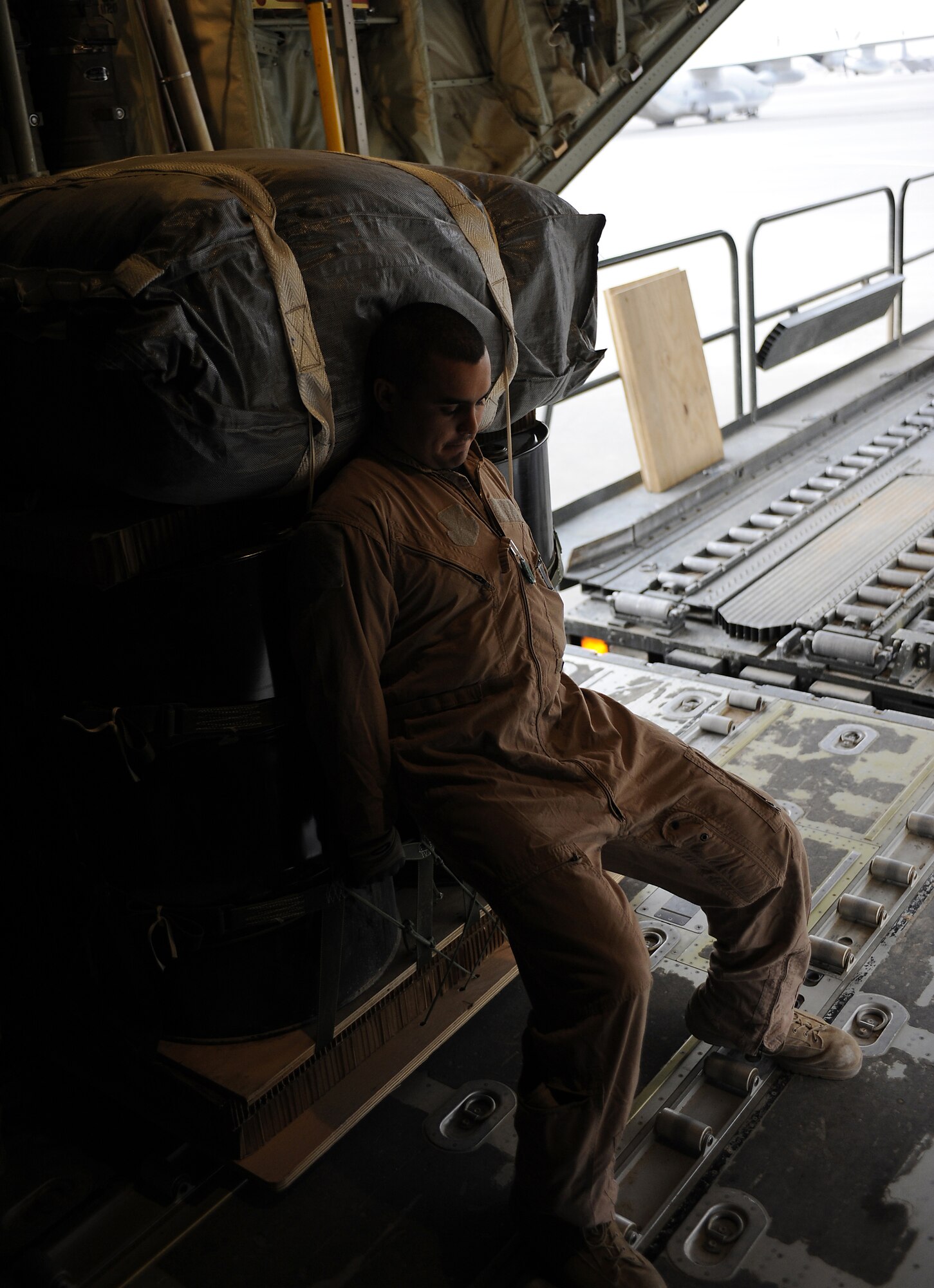 Tech. Sgt. Josh Romero positions a bundle of supplies while loading a C-130J Hercules for an airdrop mission Feb. 2, 2011, at Kandahar Airfield, Afghanistan. During the month of January, the 772nd Expeditionary Airlift Squadron moved close to 4,000 passengers and flew more than 420 sorties with approximately 400 flight hours and also broke a record by completing 51 airdrop missions in a one-month period. Sergeant Romero is a loadmaster assigned to the 772nd EAS. (U.S. Air Force photo/Senior Airman Willard E. Grande II/Released)