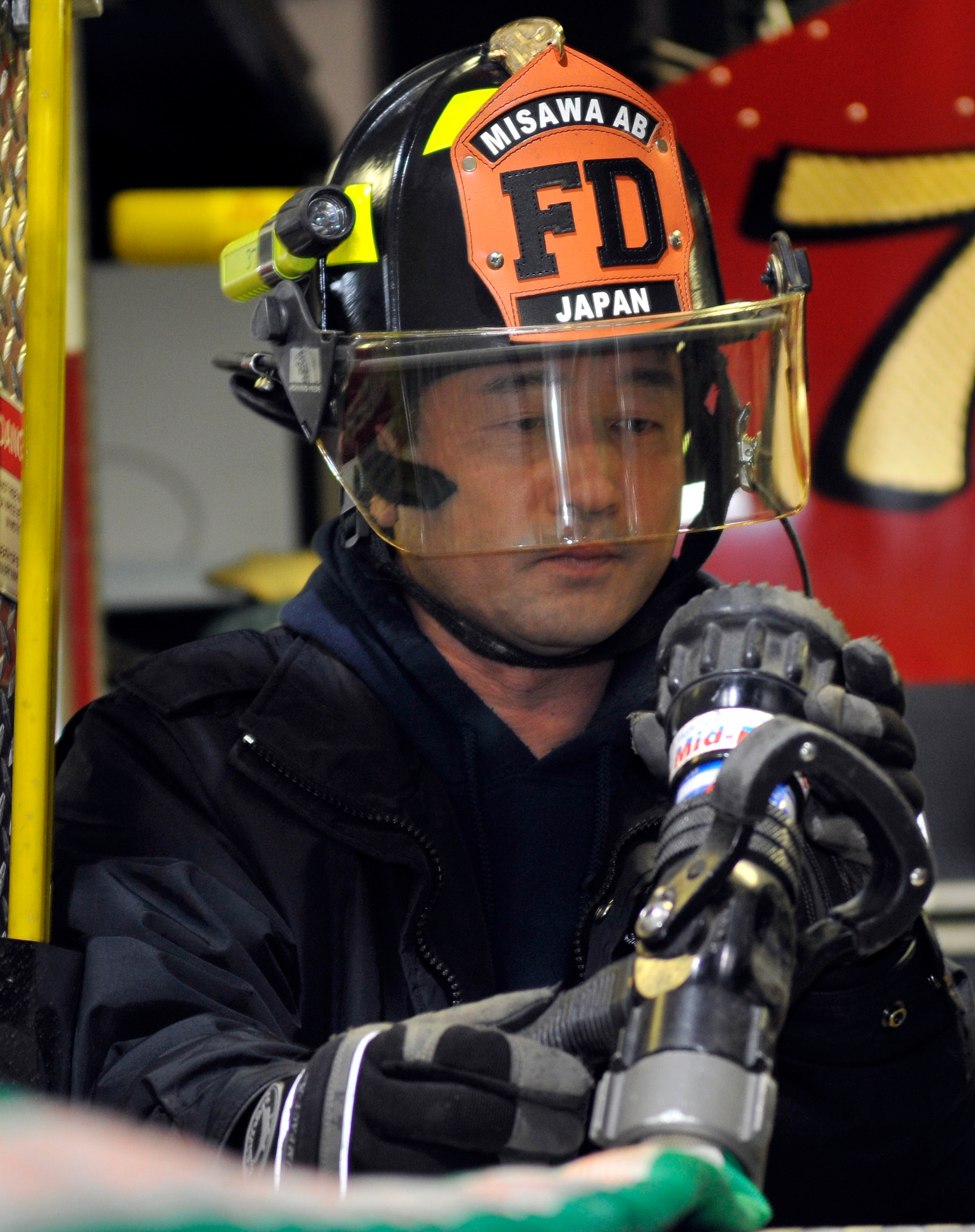 Kunihiko Tainaka, 35th Civil Engineer Squadron firefighter, inspects the nozzle of a speed lay fire hose for obstructions Feb. 3, 2011, Misawa Air Base, Japan. A fire truck may carry upwards of 2,400 feet of different size hose. Mr. Tainaka and the other firefighters routinely inspect the hoses for leaks and abrasions, which may cause loss of water pressure. (U.S. Air Force photo by Tech. Sgt. Phillip Butterfield/Released)