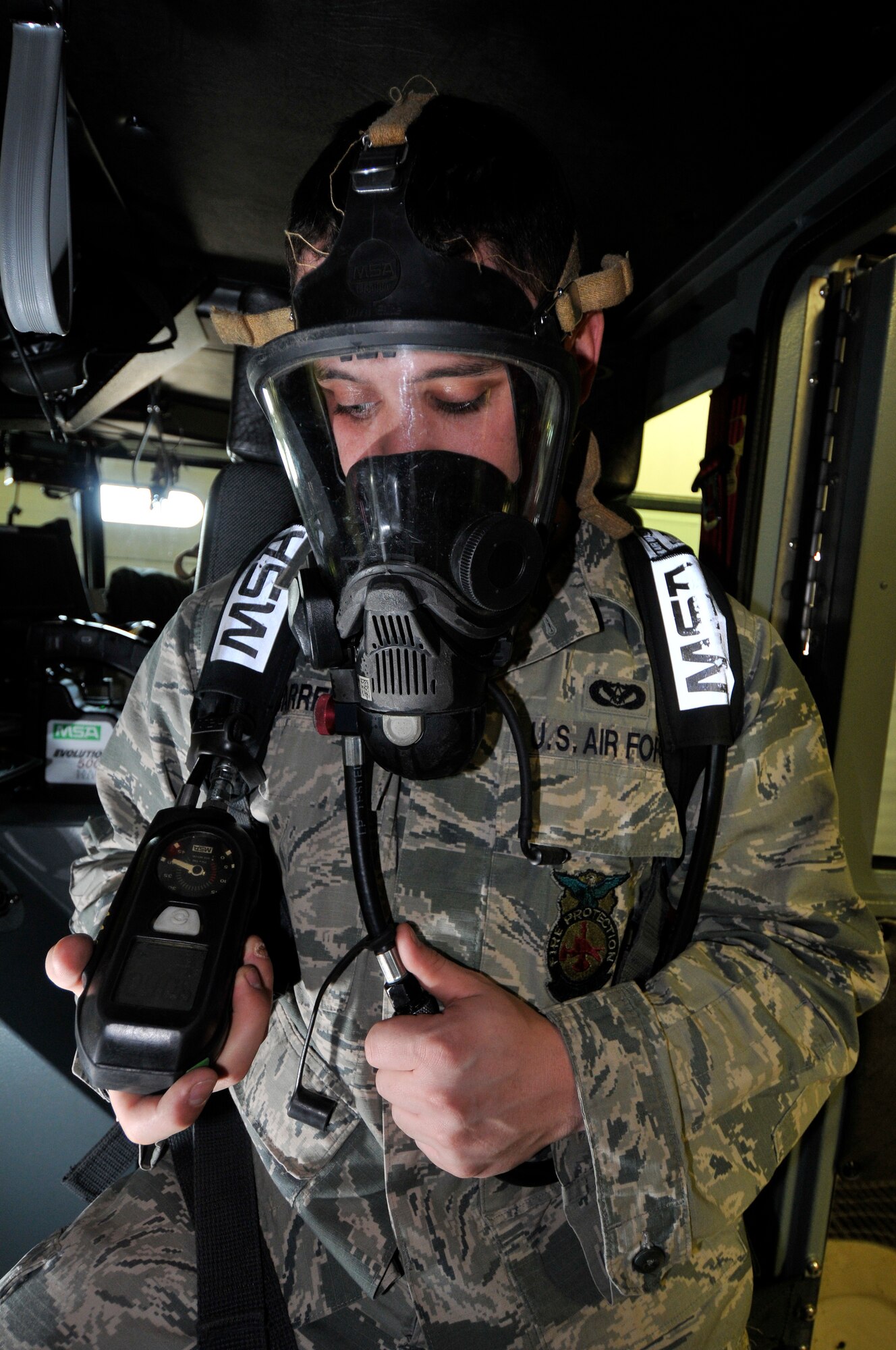 U.S. Air Force Senior Airman Christopher Carrell, 35th Civil Engineer Squadron firefighter, tests a self-contained breathing apparatus for leaks and oxygen tank levels Feb. 3, 2011, Misawa Air Base, Japan. The air pack utilizes a personal alarm safety system emits a siren and flash to alert emergency responders in the event the wearer t becomes unconscious.  (U.S. Air Force photo by Tech. Sgt. Phillip Butterfield/Released)