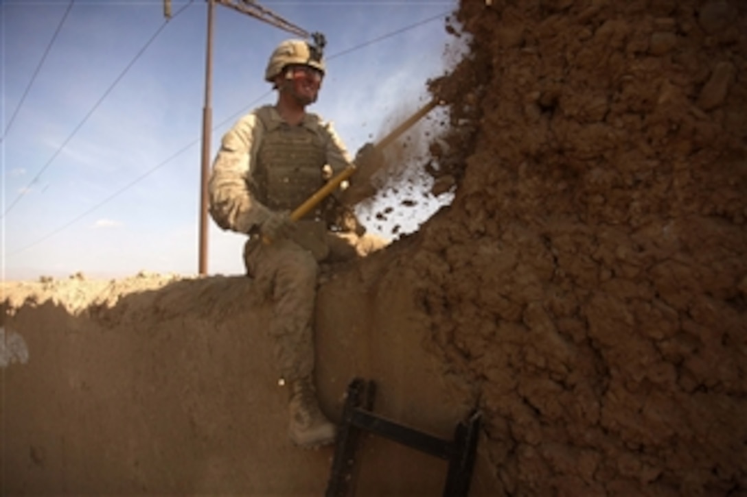 U.S. Marine Corps Lance Cpl. Joseph Rodes, with Lima Company, 3rd Battalion, 5th Marine Regiment, Regimental Combat Team 2, breaks down a wall in Sangin district, Helmand province, Afghanistan, to open sectors of fire for a post on Jan. 21, 2011.  