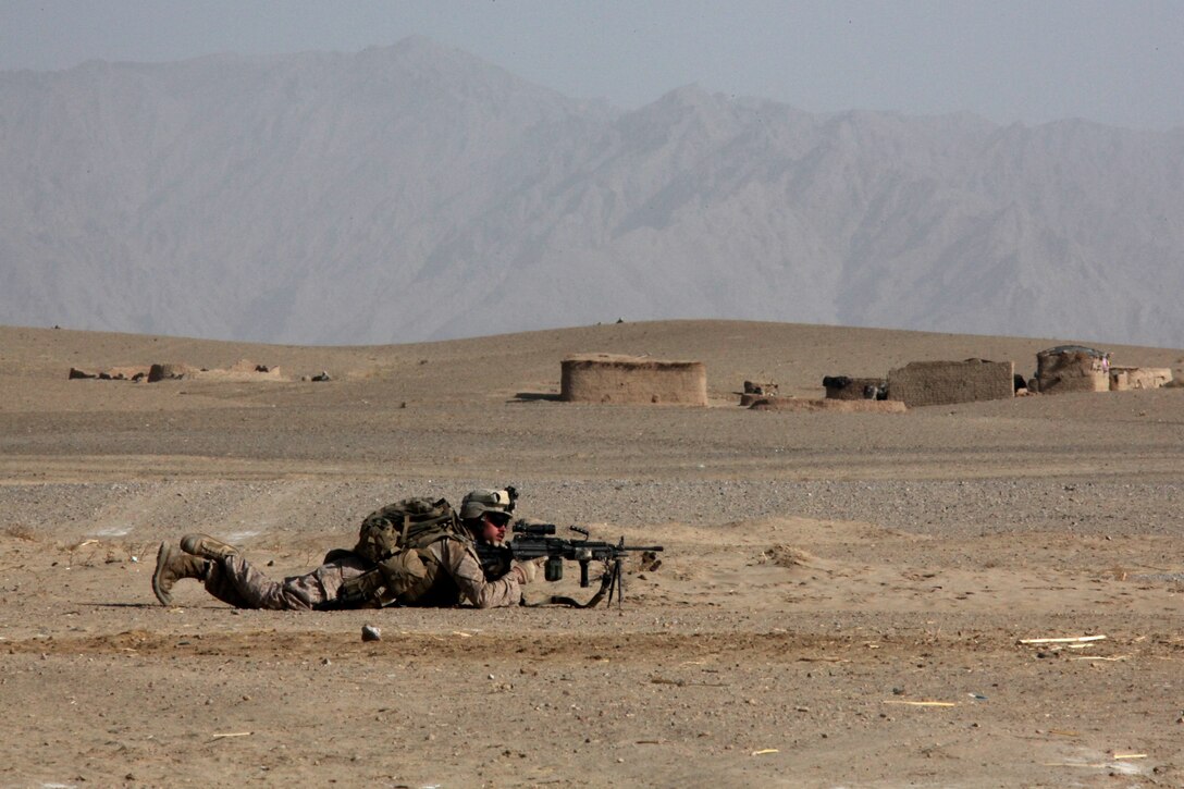 U.S. Marine Corps Lance Corporal Joshua Hutchinson, a Squad Automatic Weapon gunner with 1st Platoon, Company I, Battalion Landing Team 3/8, 26th Marine Expeditionary Unit, Regimental Combat Team 2, establishes security during a patrol near Turah Shah Ghundey, Helmand province, Afghanistan, Feb. 4, 2011. Elements of 26th Marine Expeditionary Unit deployed to Afghanistan to provide regional security in Helmand province in support of the International Security Assistance Force. (U.S. Marine Corps photo by Gunnery Sergeant Bryce Piper/Released)::r::::n::