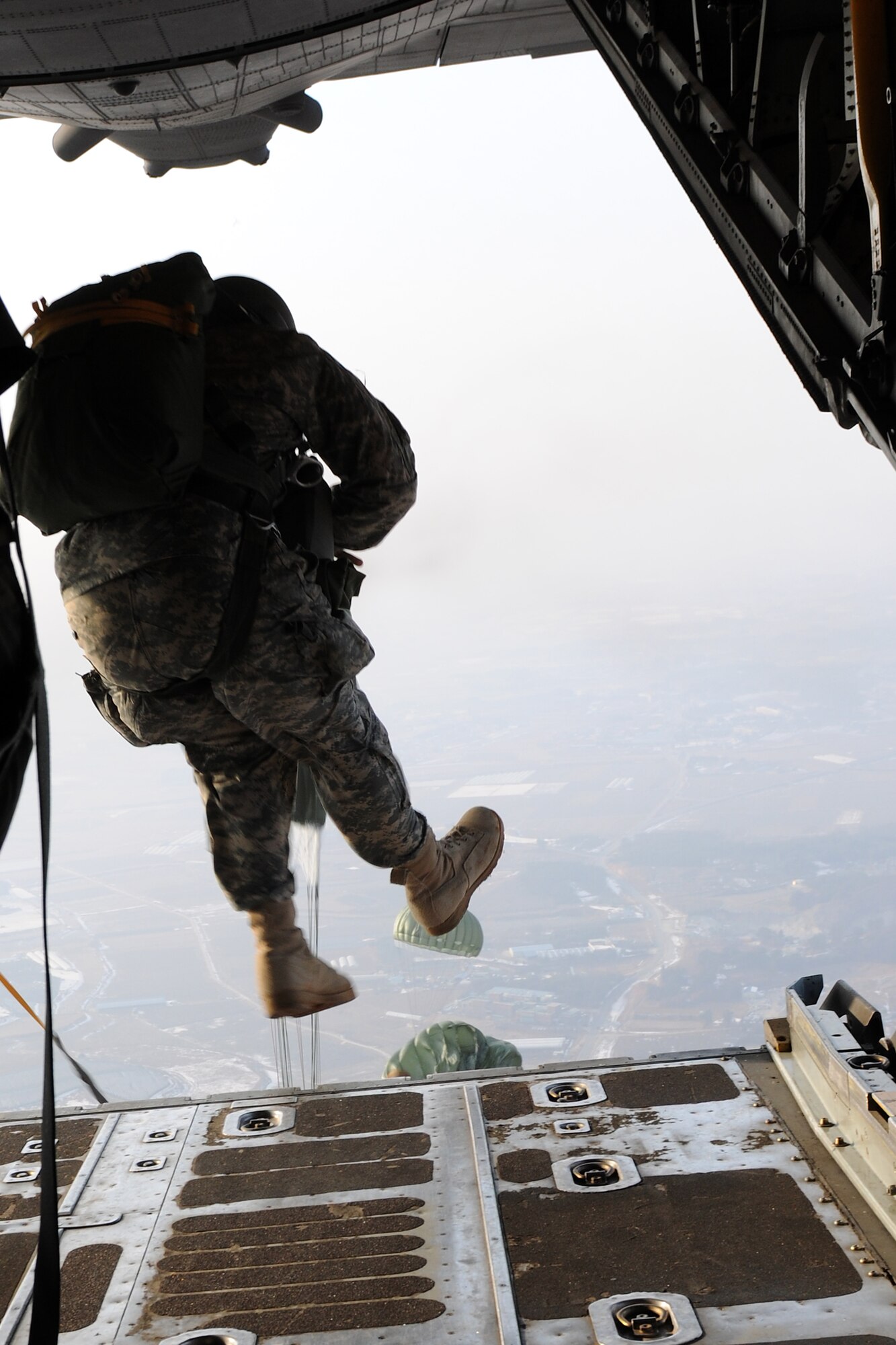 KUNSAN AIR BASE, Republic of Korea -- An Army member from the Special Operations Command Korea's 39th Special Forces Detachment performs static-line jump training from 1,250 feet out of a C-130 from Yokota Air Base, Japan, Feb. 1. The joint training flight also included Tech. Sgt. Troy Daland, 8th Operations Support Squadron NCO in charge of weapons, tactics and personnel recovery. The Air Force and SOCKOR frequently conduct aerial training missions to keep special operations forces members up to date with their training requirements. (U.S. Air Force photo/Tech. Sgt. Jonathan Pomeroy)   