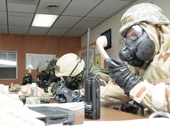 Airmen from the 916th Air Refueling Wing work in the emergency operations center during their recent inspection. Even in full chemical gear they must continue the mission. (USAF photo by TSgt. Scotty Sweatt, 916ARW/PA)