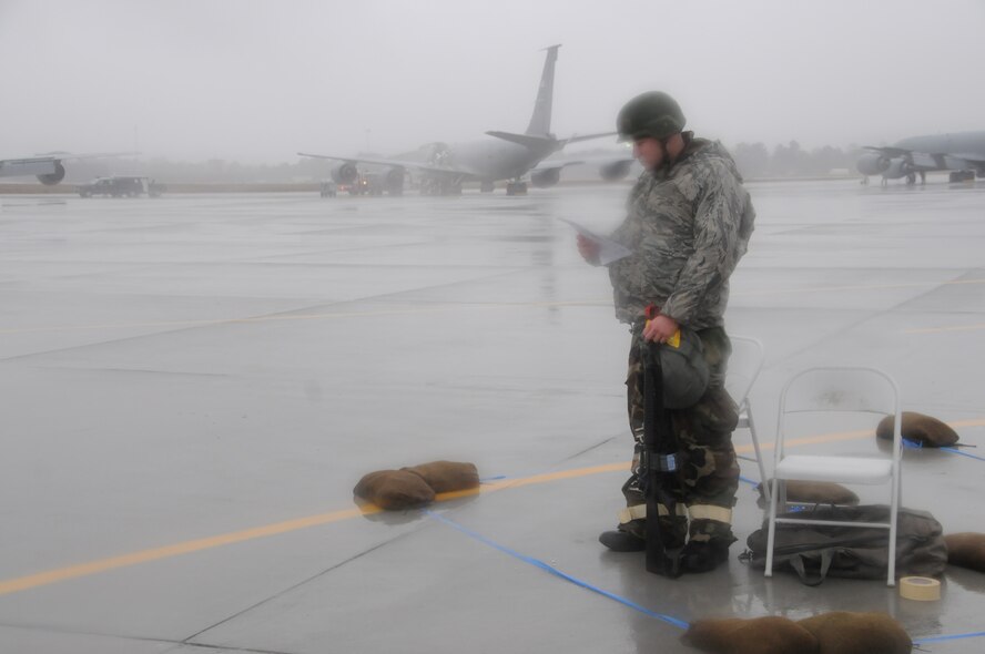 This maintainer stood in the rain to ensure the flightline and perimeter was safe during the recent inspection. We did catch him keeping up on the latest news by reading the wing's simulated deployed newsletter. (USAF photo by TSgt. Scotty Sweatt, 916ARW/PA)