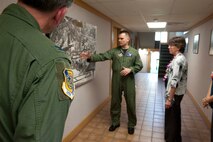 Col. Joe Dague, 15th Wing vice commander, looks on as Capt. John Cortney, 15th Operations Support Squadron C-17 Instructor Pilot, points out areas of interest on on a map of Hickam to Mrs. Lorrie Kresge at the base operations building Feb. 3 at Joint Base Pearl Harbor Hickam, Hawaii. During her visit to base operations, Mrs. Kresge  was briefed on the building's history as well as its function within the wing. (U.S. Air Force photo/Staff Sgt. Nathan Allen)