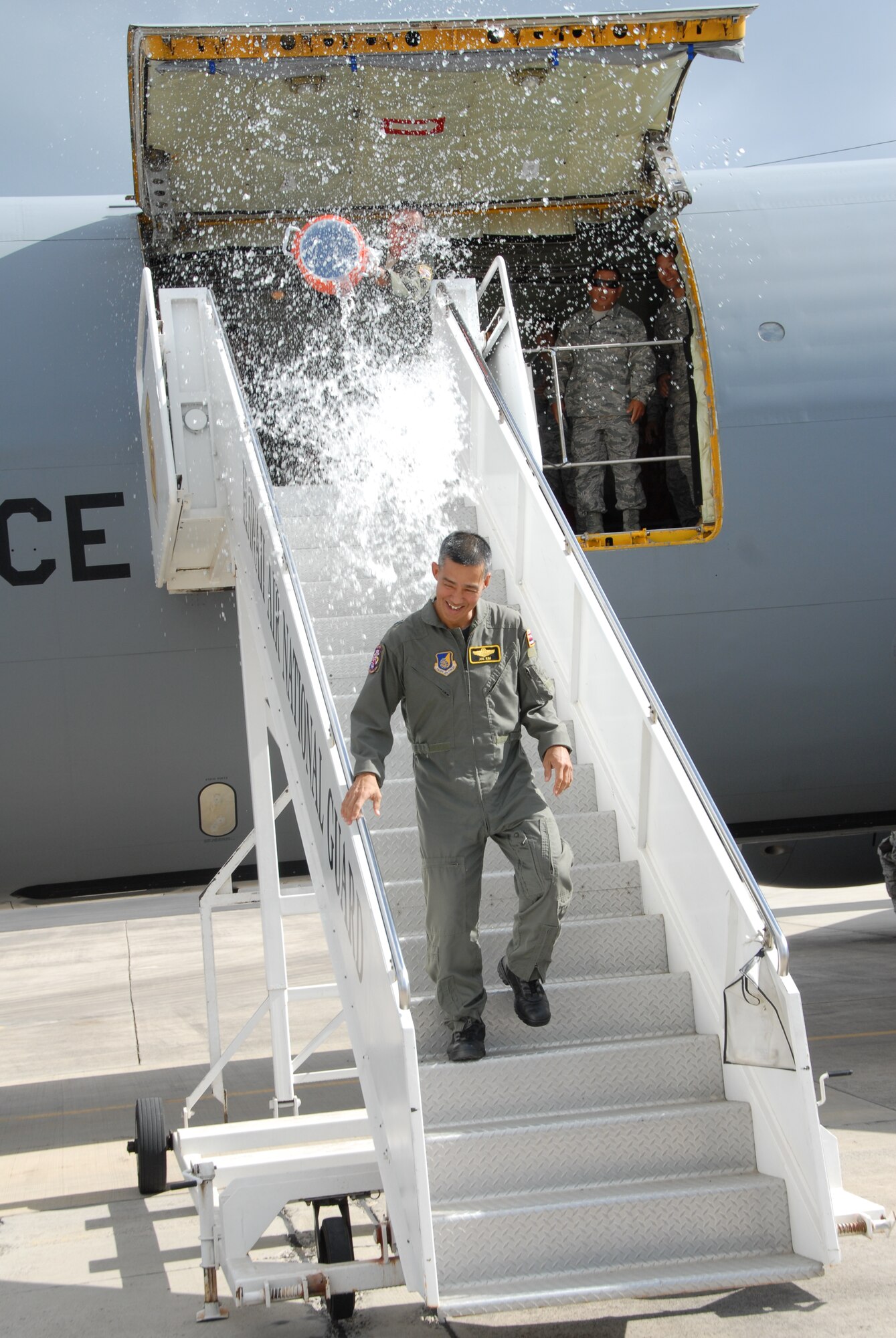 Brig. Gen. Joseph Kim, outgoing 154th Wing commander, gets soaked by a fellow crew member while exiting the KC-135 aircraft after his final flight on Joint Base Pearl Harbor-Hickam, Hawaii Feb. 3. Members of the 154th Wing and the active duty 15th Wing partner together through total force integration to fly and maintain aircraft here. (U.S. Air Force Photo/Master Sgt. Kristen Stanley)