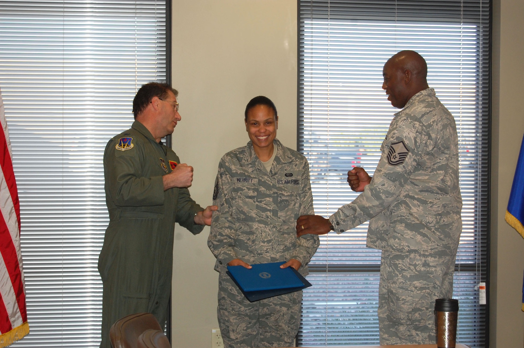 NELLIS AIR FORCE BASE, Nev. -- (Center) Master Sgt. Aisha Merritt has her new rank tacked on by Col. Herman Brunke, 926th Group commander, and Master Sgt. Phillip Hayes, 926th Group first sergeant, during her promotion ceremony here Feb. 1. Sergeant Merritt is a personnel specialist with the 706th Fighter Squadron. (U.S. Air Force photo/Capt. Jessica Martin)