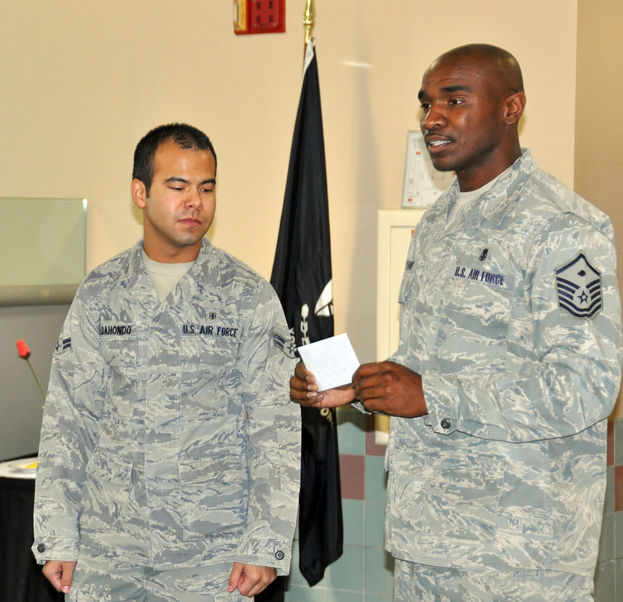 Airman 1st Class Ricardo Aldahonda, 60th Medical Support Squadron receives the Travis First Sergeant Association $250 Dan Webster scholarship during a first sergeant meeting Wednesday. U.S. Air Force photo/Airman 1st Class Michael Battles