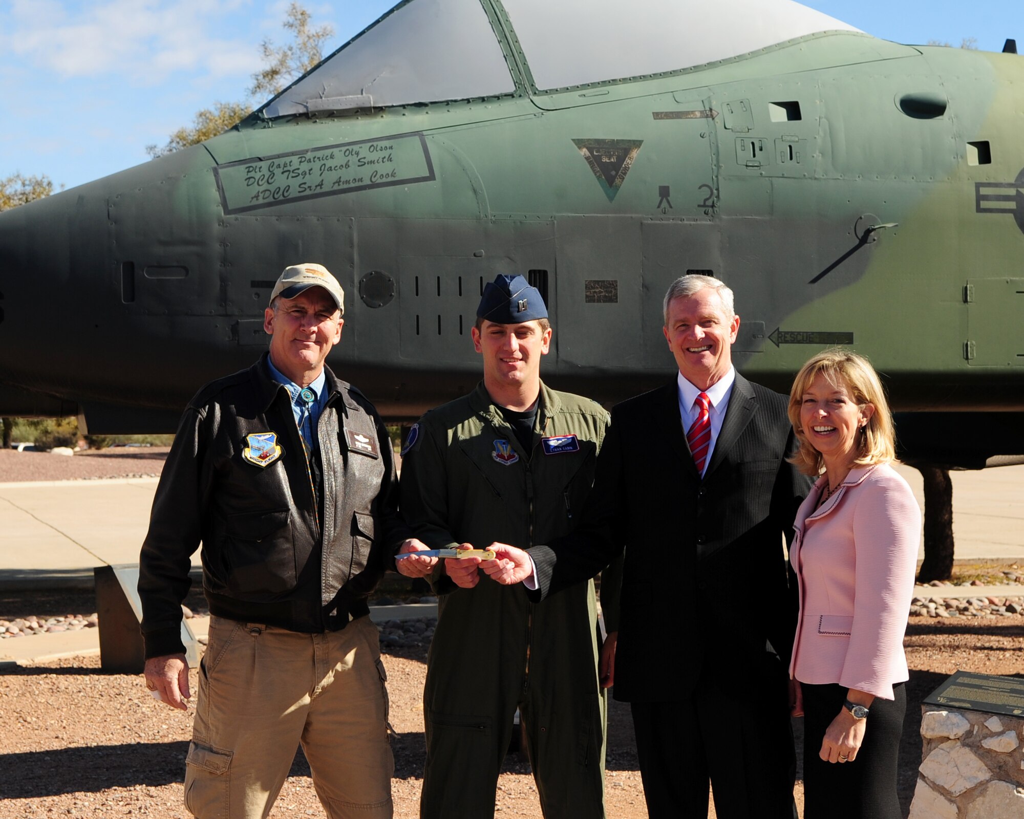 DAVIS-MONTHAN AIR FORCE BASE, Ariz. - Capt. Ethan Sabin, a fighter pilot from the 354th Fighter Squadron, holds an honorary knife with retired Brig. Gen. Guy Walsh of the Maryland Air National Guard, Robin Stoddard, a Distributed Mission Operation Site Manager, and Colleen Shine, daughter of Col. Shine, here Feb. 1. The knife is presented alongside of the Shine Award to pay homage to Colonel Shine, who was an avid collector. (U.S. Air Force photo/Airman 1st Class Jerilyn Quintanilla)