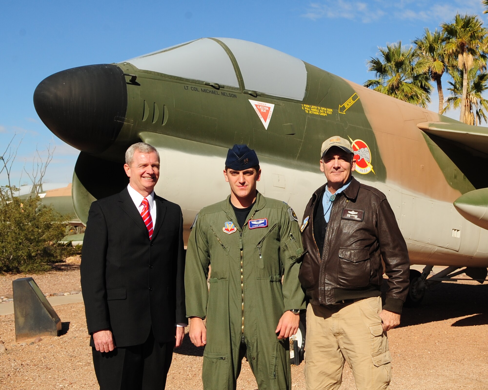 DAVIS-MONTHAN AIR FORCE BASE, Ariz. - Capt. Ethan Sabin, a fighter pilot from the 354th Fighter Squadron, stands in front of an A-7 fighter jet with retired Brig. Gen. Guy Walsh of the Maryland Air National Guard, and Robin Stoddard, a Distributed Mission Operation Site Manager, here Feb. 1. General Walsh and Mr. Stoddard are previous recipients of the prestigious award. (U.S. Air Force photo/Airman 1st Class Jerilyn Quintanilla)
