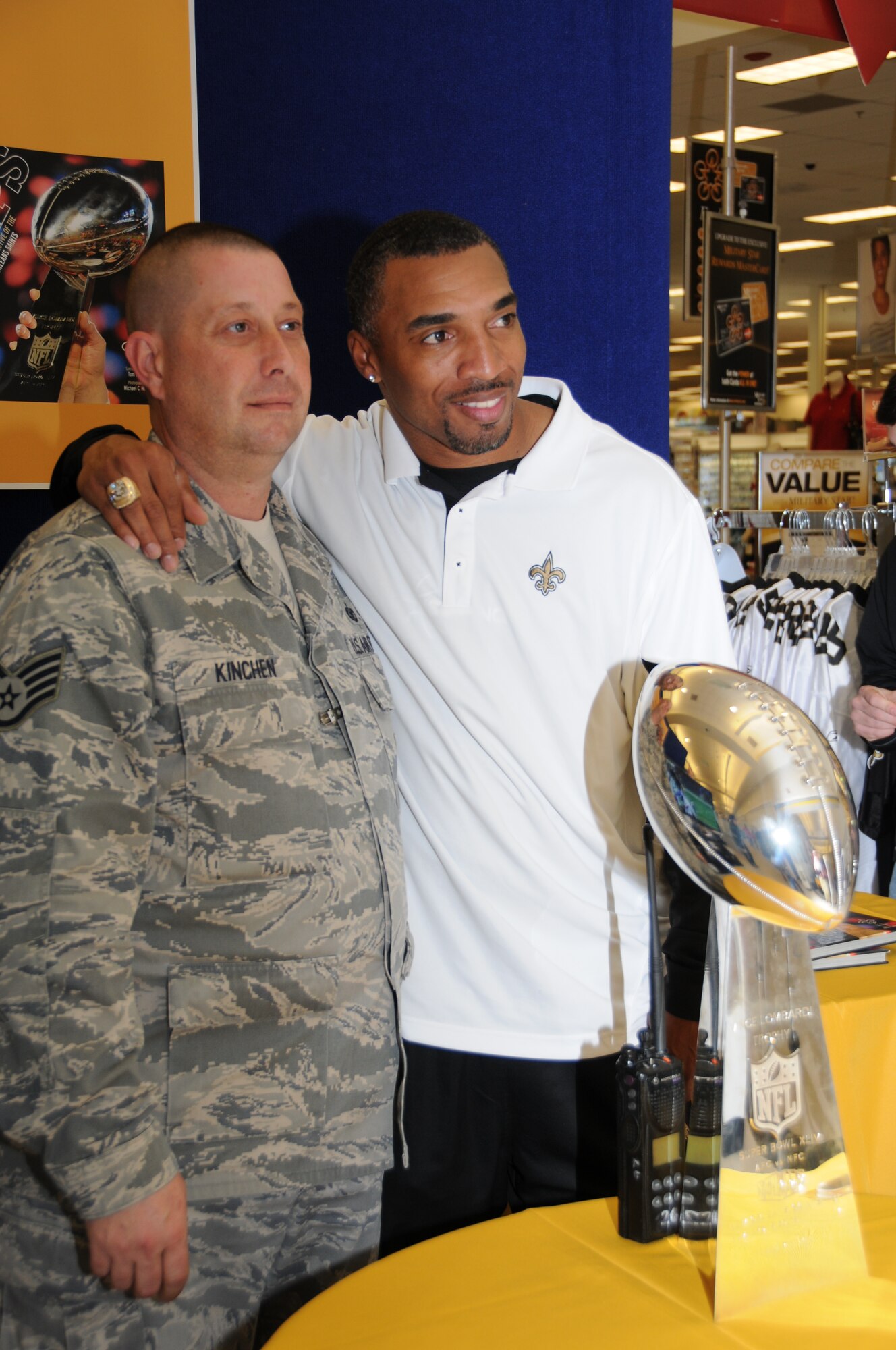 Left, Staff Sgt. Lee Kinchen, 81st Security Forces Squadron, poses with former NFL player 
ichael Lewis of the New Orleans Saints and the Saints' Super Bowl Trophy, Feb. 4, 2011  at the Base Exchange