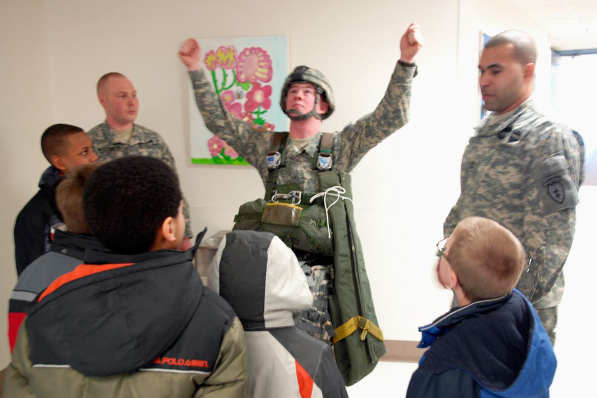 Sgt. 1st Class Tony Ayabarreno, center, a signal support systems specialist with 2-377th PFAR, shows Orion Elementary School students how paratroopers control their parachutes. (U.S. Army photo/Sgt. Marcus Butler)