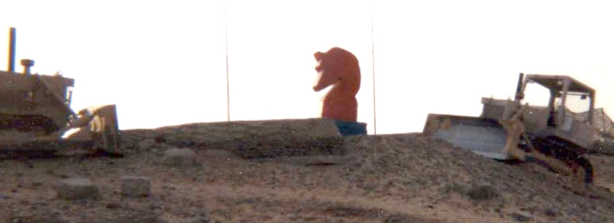 After being painted blue with fairy wings by a local Mobility Squadron in Egypt, the horse statue was confiscated by the 823rd RED HORSE Squadron and returned to its original state in 1995.  They placed it on the tallest dune they could find, and surrounded it by their equipment.  (U.S. Air Force photo/Airman Cortney Hansen)