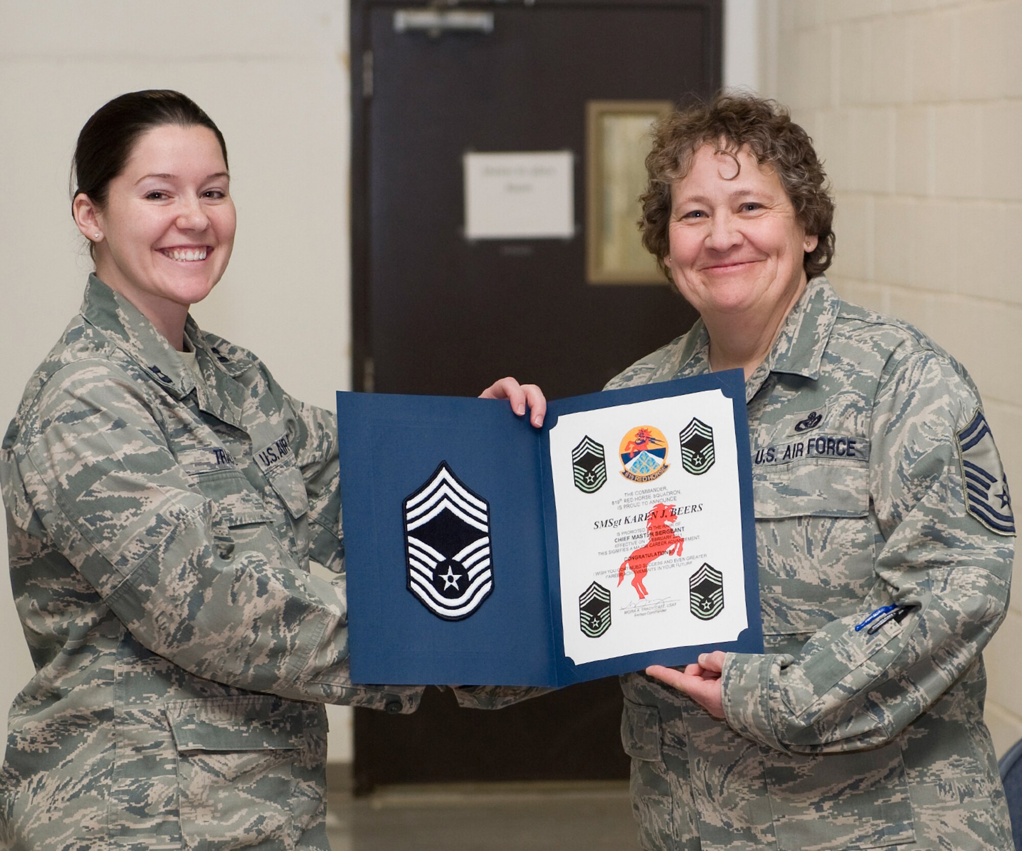 Capt. Moira Tracy, acting 819th RED HORSE Squadron commander (left), and Senior Master Sgt. Karen Beers, a mechanical superintendent for the 819th RHS, pose with the new chief's promotion certificate Jan. 31 prior their monthly promotion ceremony where she was given her new rank. (U.S. Air Force photo/Beau Wade)