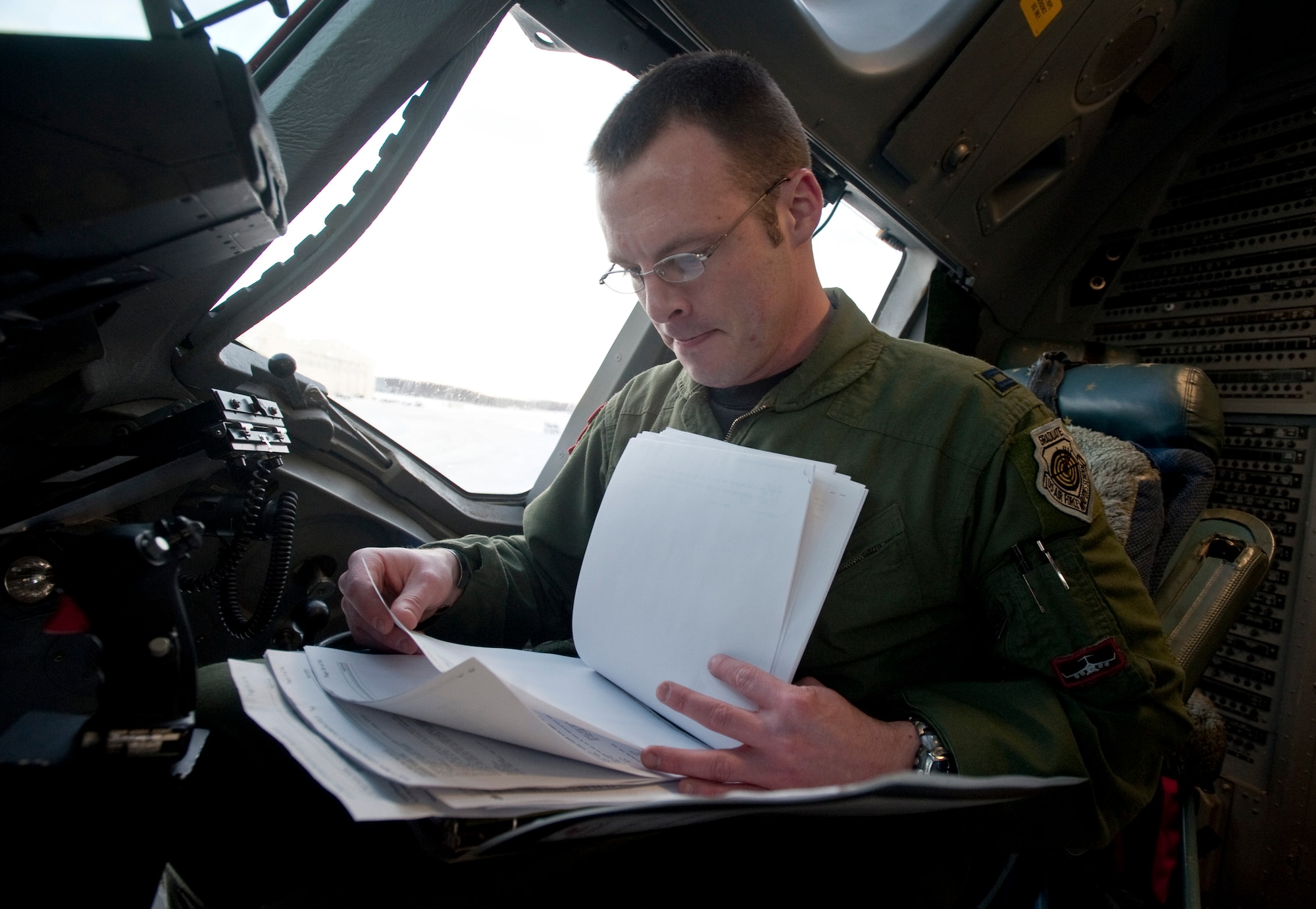 JOINT BASE ELMENDORF-RICHARDSON, Alaska -- Capt. Allen Morris, 517th Airlift Squadron weapons officer and tactics flight commander, goes through paper work before taking off for a flight Jan. 27. Captain Morris was recently named the winner of the 2010 Daedalian Exceptional Pilot Award at the Pacific Air Forces level. (Air Force photo by Airman 1st Class Christopher Gross)