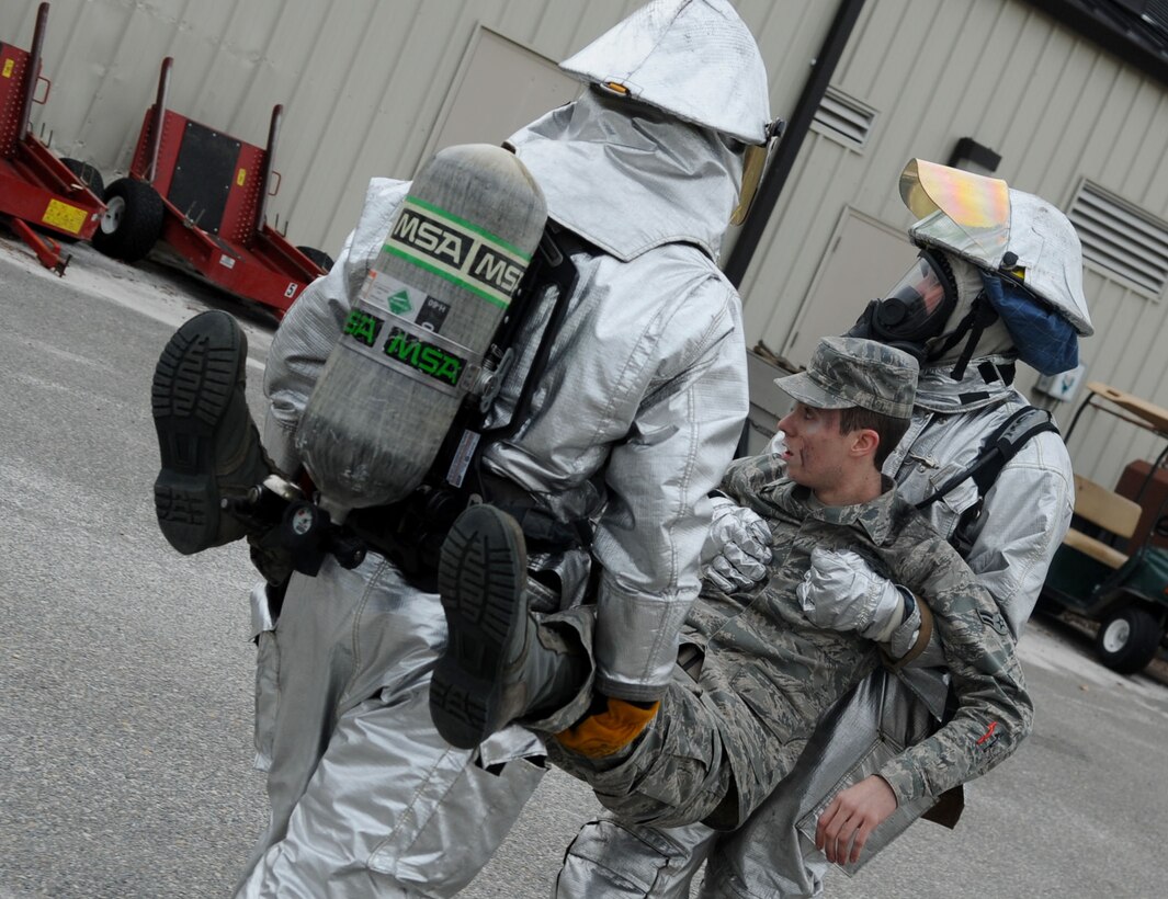 LANGLEY AIR FORCE BASE, Va. -- Staff Sgt. Joseph Dunn and Senior Airman Ryan Gross, 633d Civil Engineer Squadron Fire Department firefighters, carry Airman 1st Class Seth Dillinger, 633d Medical Group Pharmacy technician, away from the scene of a simulated explosion during a Major Accident Response Feb. 4. MAREs are held on a semi-annual basis to certify and train emergency responders on the skills needed to perform efficiently should an actual incident occur. (U.S. Air Force photo / Senior Airman Wesley Farnsworth) (RELEASED)