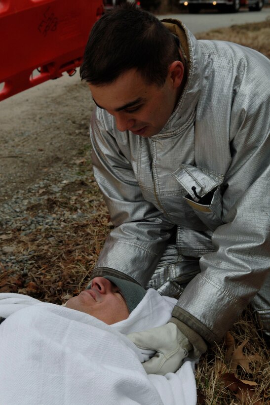LANGLEY AIR FORCE BASE, Va. -- Staff Sgt. Jesse Zainey, 633d Civil Engineer Squadron Fire Department firefighter, talks to Senior Master Sgt. Tony Gurrola, 633d Medical Group Surgical Service Squadron superintendent and simulated accident victim, while stabilizing his head and neck during a Toxic Industrial Chemical/Toxic Industrial Material simulation here, Feb. 4. The Major Accident Response Exercise was held as a required semi-annual evaluation to examine first respnders' ability to quickly react and stabilize real-world emergencies. (U.S. Air Force photo/Airman 1st Class Racheal Watson)(RELEASED)