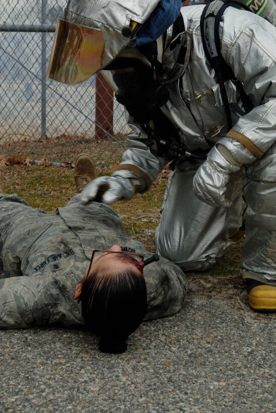 LANGLEY AIR FORCE BASE, Va. -- Staff Sgt. Joseph Dunn, 633d Civil Engineer Squadron Fire Department firefighter, checks the status of Airman Jessica Howe, 633d Medical Group Dental Squadron assistant, after a chemical explosion during a Toxic Industrial Chemical/Toxic Industrial Material simulation here, Feb. 4. The Major Accident Response Exercise was held as a required semi-annual evaluation to examine first respnders' ability to quickly react and stabilize real-world emergencies.(U.S. Air Force photo/Airman 1st Class Racheal Watson)(RELEASED)