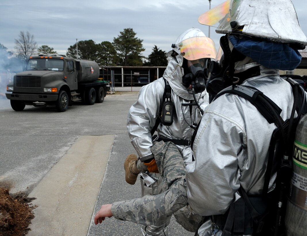 LANGLEY AIR FORCE BASE, Va. -- Staff Sgt. Joseph Dunn and Senior Airman Ryan Gross, 633d Civil Engineer Squadron firefighters, carry Airman Jessica Howe, 633d Medical Group dental technician, away from the scene of a simulated explosion during a Major Accident Response Exercise Feb. 4. MAREs are held on a semi-annual basis to certify and train base emergency responders. (U.S. Air Force photo / Senior Airman Wesley Farnsworth) (RELEASED)