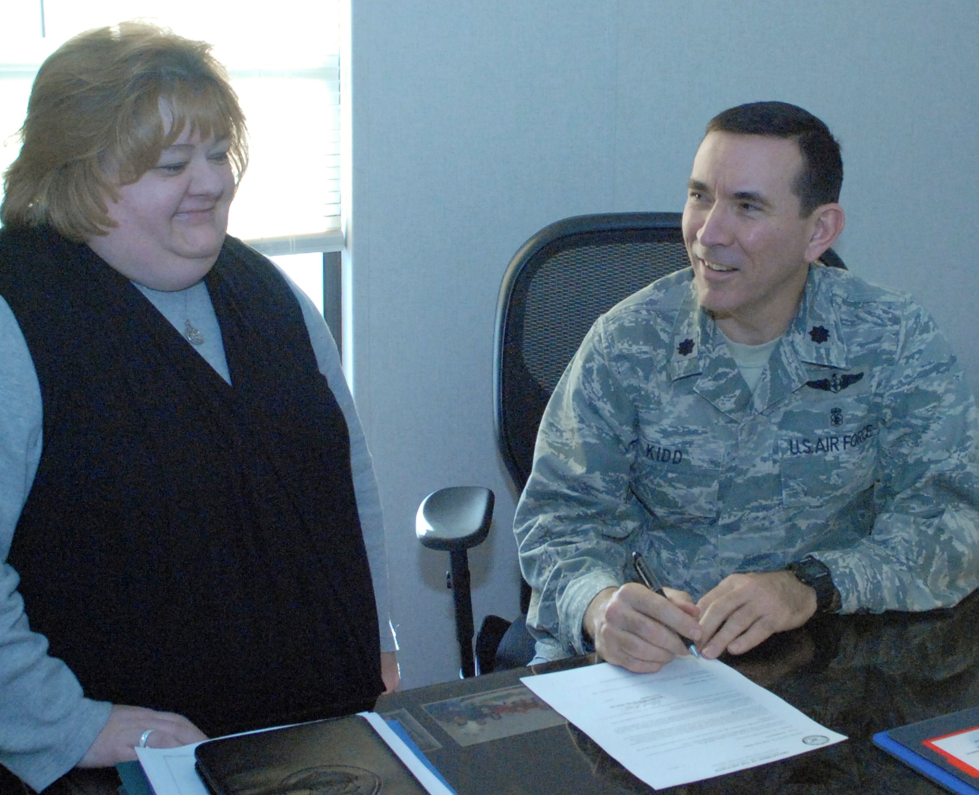 Deanna Ash, 436th Medical Operations Squadron secretary, discusses upcoming events with Lt. Col. Allen Kidd, 436th MDOS commander and 436th Medical Group interim commander Feb. 3, 2011, at Dover Air Force Base, Del. As Colonel Kidd's secretary, Mrs. Ash maintains his schedule of events and keeps him updated on what is going on around the squadron. (U.S. Air Force photo/Airman 1st Class Matthew Hubby)