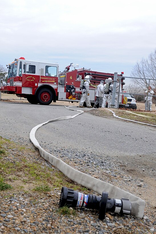 LANGLEY AIR FORCE BASE, Va. -- The 633d Civil Engineer Squadron Fire Department readies equipment before extinguishing a fire during a Toxic Industrial Chemical/Toxic Industrial Material simulation here, Feb. 4. The Major Accident Response Exercise is held semi-annually to evaluate first respnders' ability to quickly react and stabilize real-world emergencies. (U.S. Air Force photo/Staff Sgt. Ashley Hawkins)(RELEASED)