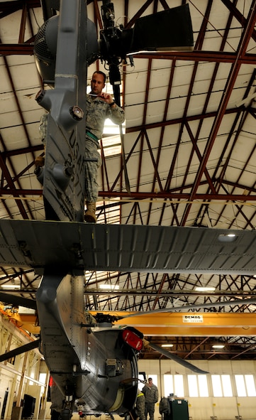 MOODY AIR FORCE BASE, Ga.-- Senior Airman Casey Scaffide, 41st Helicopter Maintenance Unit crew chief, stands on the tail pylon of an HH-60G Pave Hawk helicopter during maintenance recently. A group of maintainers, crew chiefs and hydraulic technicians worked simultaneously to get the Pave Hawk out of the maintenance shop and back to flying status. (U.S. Air Force photo/Airman 1st Class Benjamin Wiseman)(RELEASED)
