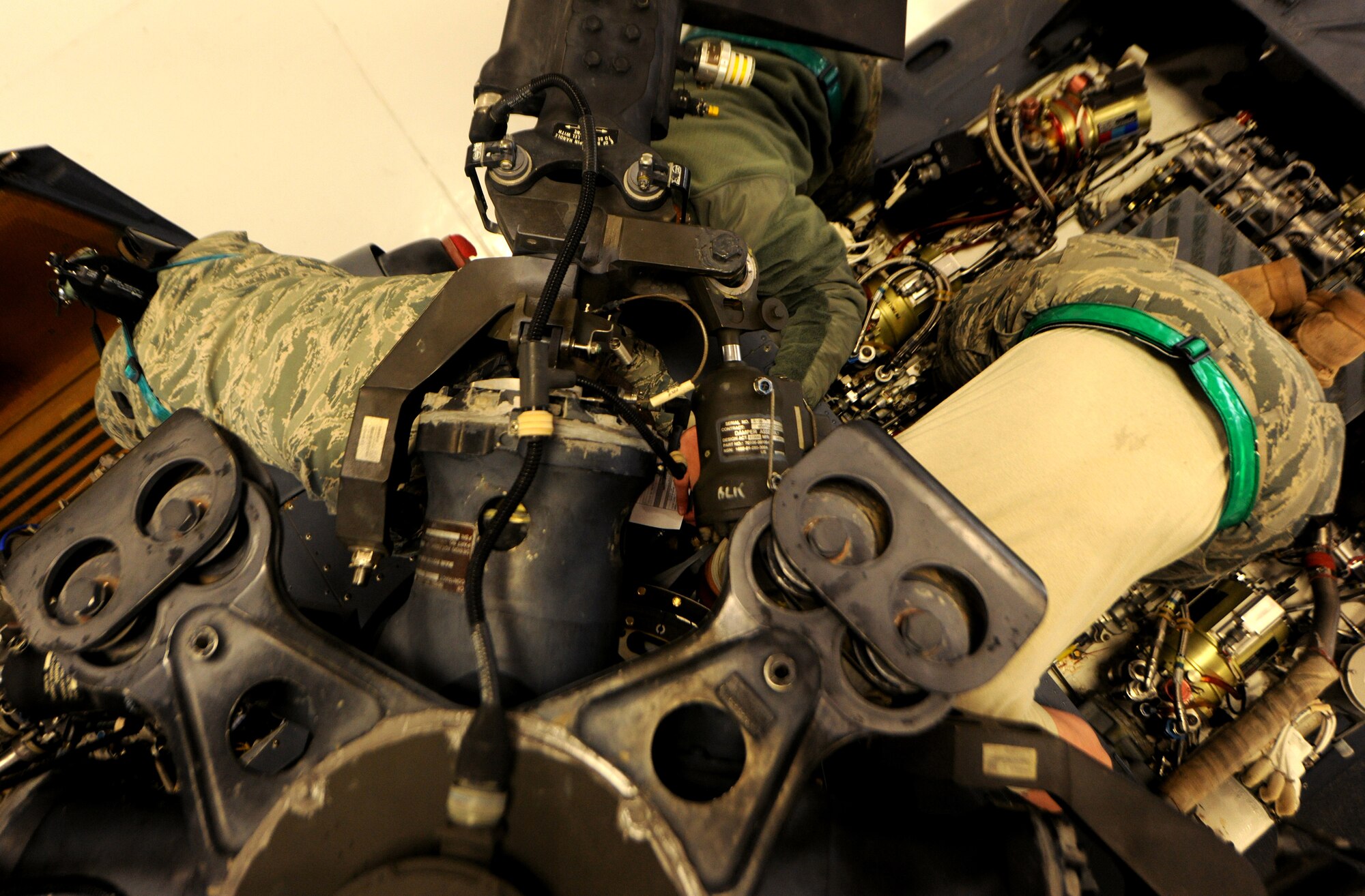 MOODY AIR FORCE BASE, Ga.-- Three members from the 41st Helicopter Maintenance Squadron work at the base of the main rotor head  of an HH-60G Pave Hawk helicopter during routine maintenance recently. The crews work in conjunction with the technical orders to ensure all maintenance is done correctly. (U.S. Air Force photo/Airman 1st Class Benjamin Wiseman)(RELEASED)
