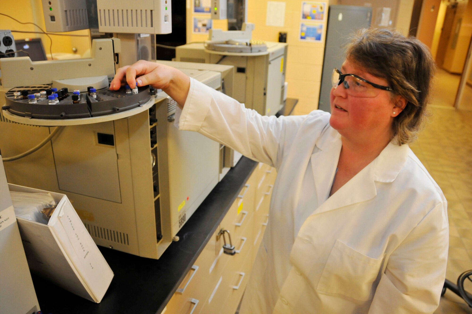 Penny Miller, an ATA senior chemist at Arnold AFB’s Chemistry Lab, loads a water sample into the auto-sampler of a gas chromatograph to determine the concentration of ethylene and propylene glycol.  (Photo by Rick Goodfriend)