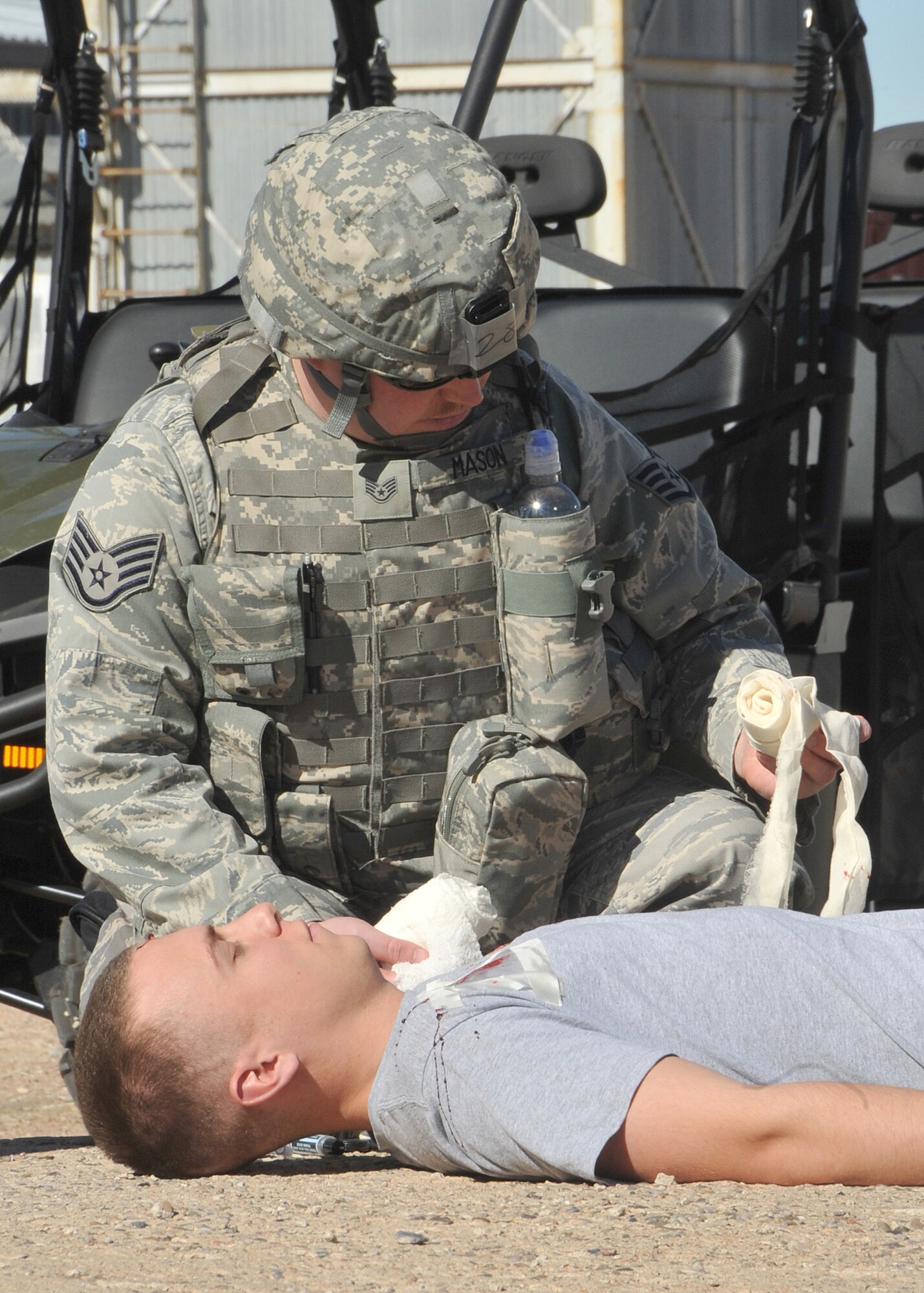Staff Sgt. Michael Mason, 377th Security Forces Squadron, conducts first-aid on Airman 1st Class  Carl Schnieder, 377th Medical Group, as part of an exercise at Coyote Canyon.  U.S. Air Force Photo by Todd Berenger.