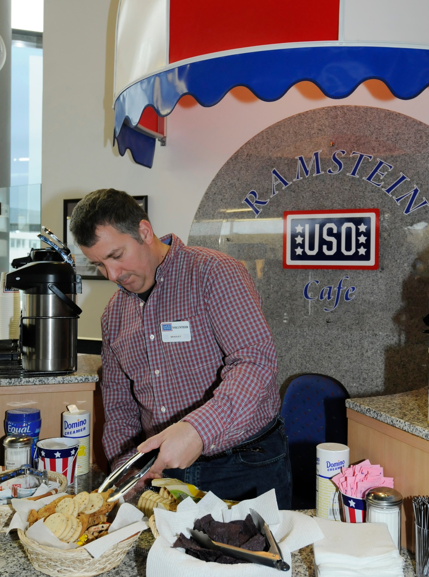 Retired U.S. Air Force Tech. Sgt. Bradley Wall restocks the United Service Organizations cafe located in the Ramstein Passenger Terminal, Ramstein Air Base, Germany, Feb. 4, 2011. Mr. Wall volunteers at the USO and Wounded Warrior Center weekly to give back to the military. (U.S. Air Force photo by Airman Kendra Alba)