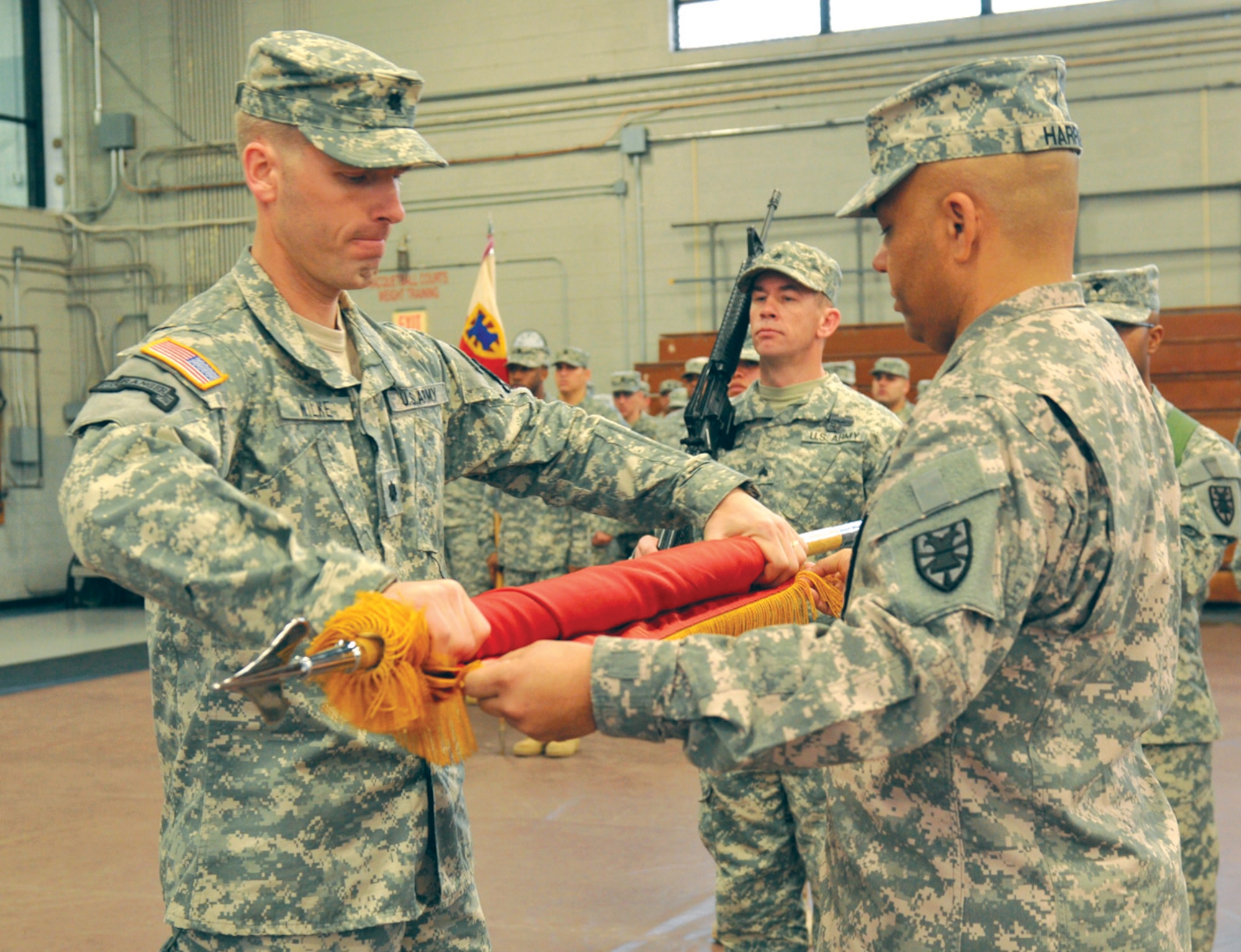 Lt. Col. Steven Wilke (left), and Command Sgt. Maj. John Harris (right), Special Troops Battalion command team, roll the battalion colors for casing. The STB will deploy to Afghanistan next month in support of overseas contingency operations.

