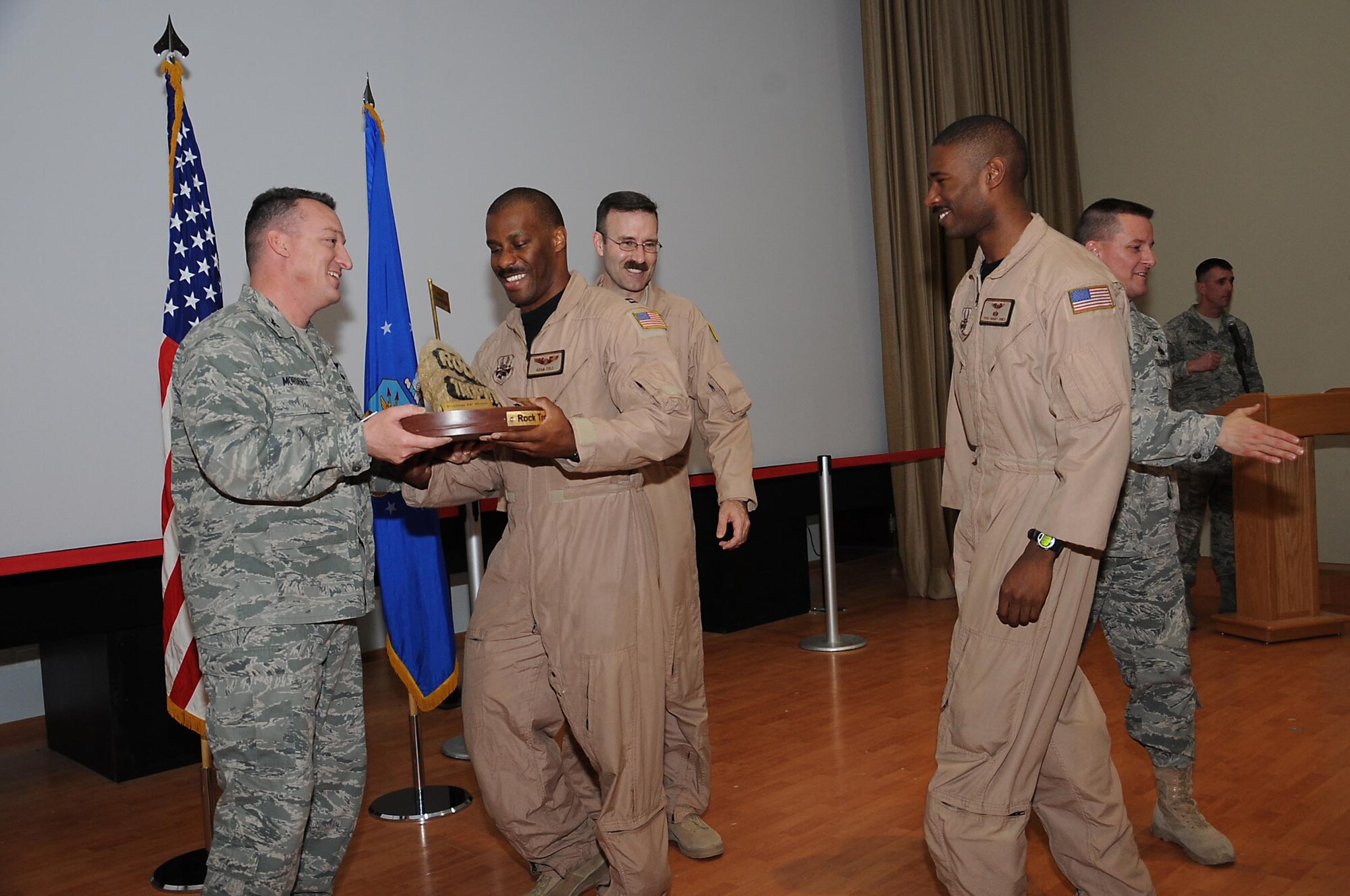 Capt. Adam Cole, a C-130H Hercules pilot from the 737th Exeditionary Airlift Squadron, recieves the Rock Trophy from Col. Patrick Mordente, 386th Air Expeditionary Wing commander, during the monthly awards ceremony here Feb. 1. The 737th EAS won the month long, seven event Rock Trophy Challenge with a cumalitive point score of 124 which was 27 points ahead of the squadron in second place, the 386th Expeditionary Contracting Squadron. (U.S. Air Force photo by Senior Airman Cynthia Spalding)